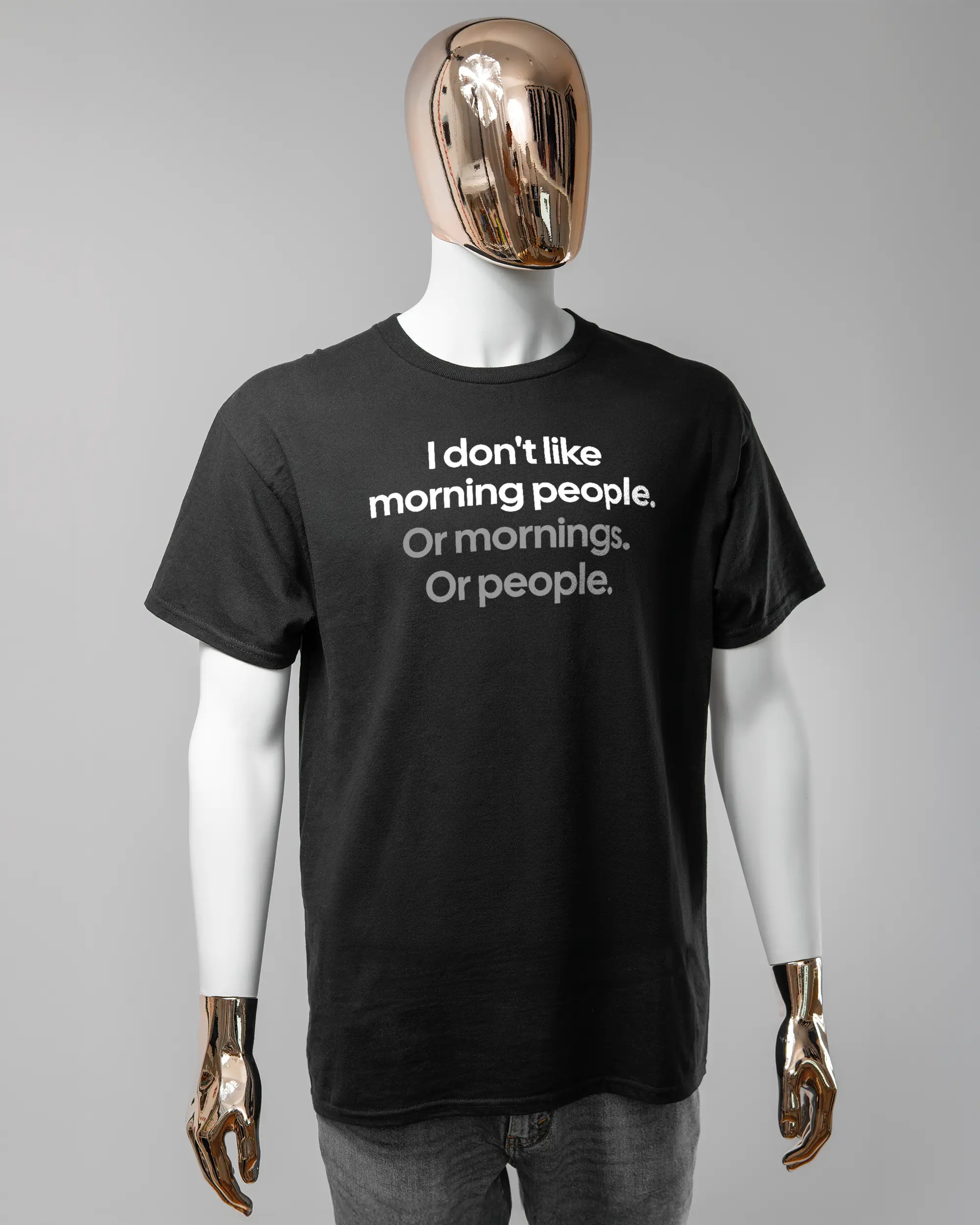 Vorderseite des Basic Unisex T-Shirt Regular von Maondo mit dem Design Morning Person in der Farbe Black und in der Größe L getragen von einer maskulinen Puppe