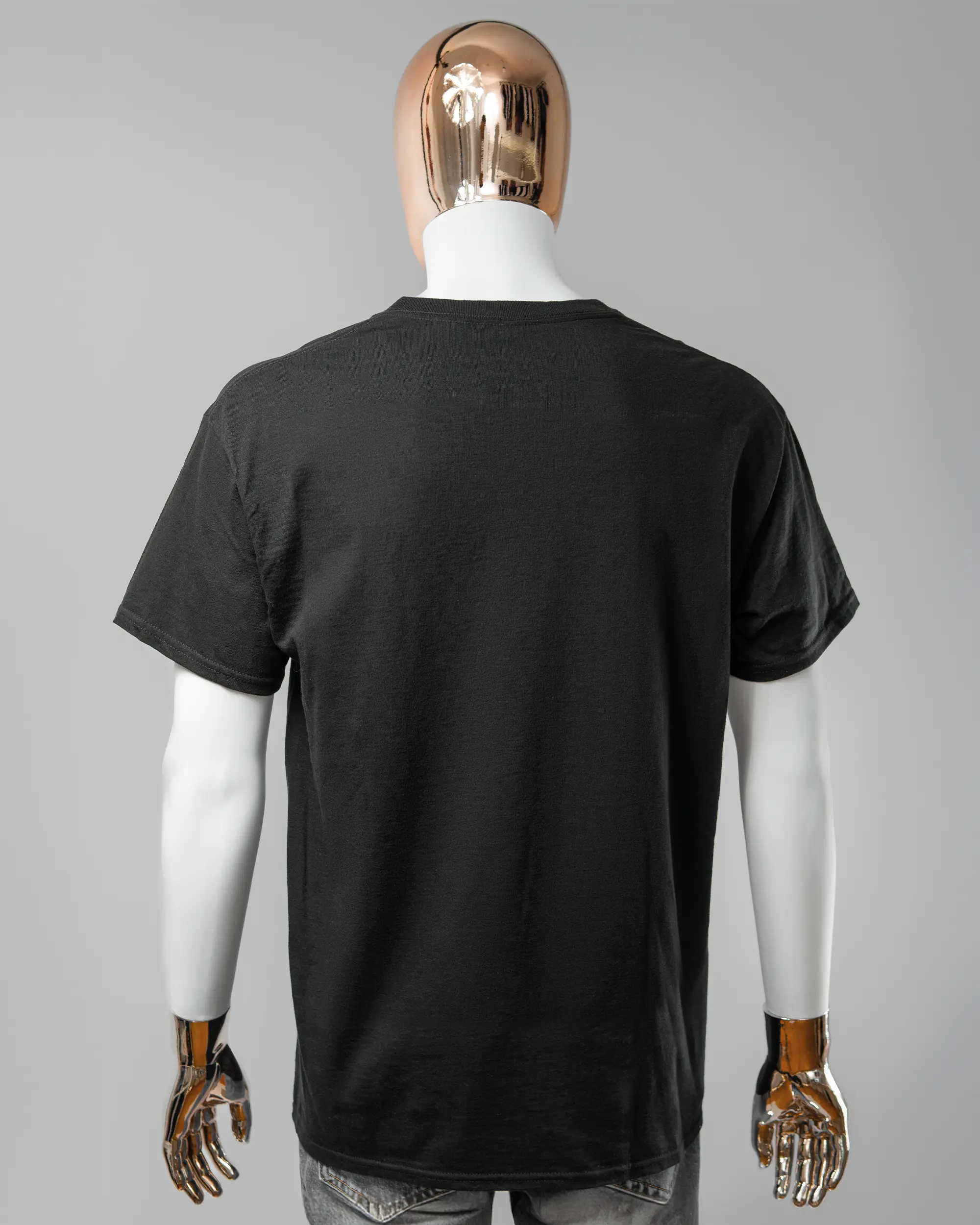 Rückseite des Basic Unisex T-Shirt Regular von Maondo ohne Motiv in der Farbe Black und in der Größe L getragen von einer maskulinen Puppe