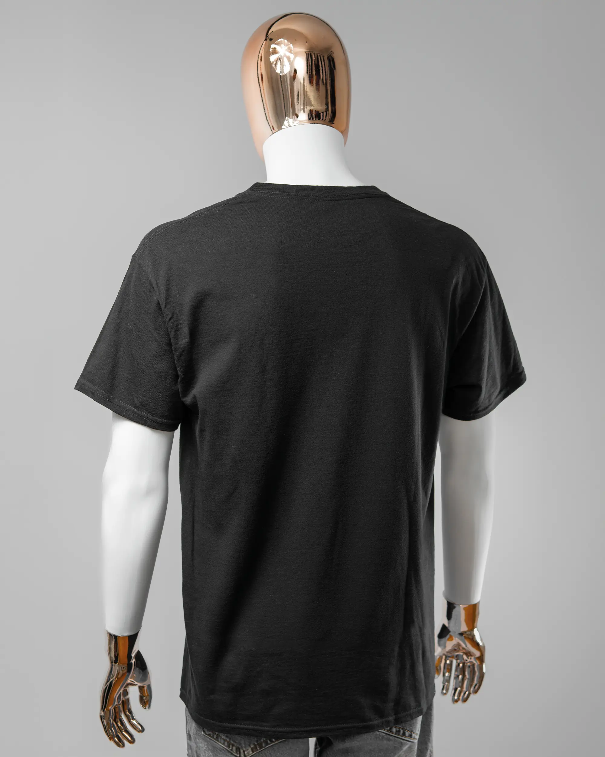 Rückseite des Basic Unisex T-Shirt Regular von Maondo ohne Motiv in der Farbe Black und in der Größe L getragen von einer maskulinen Puppe