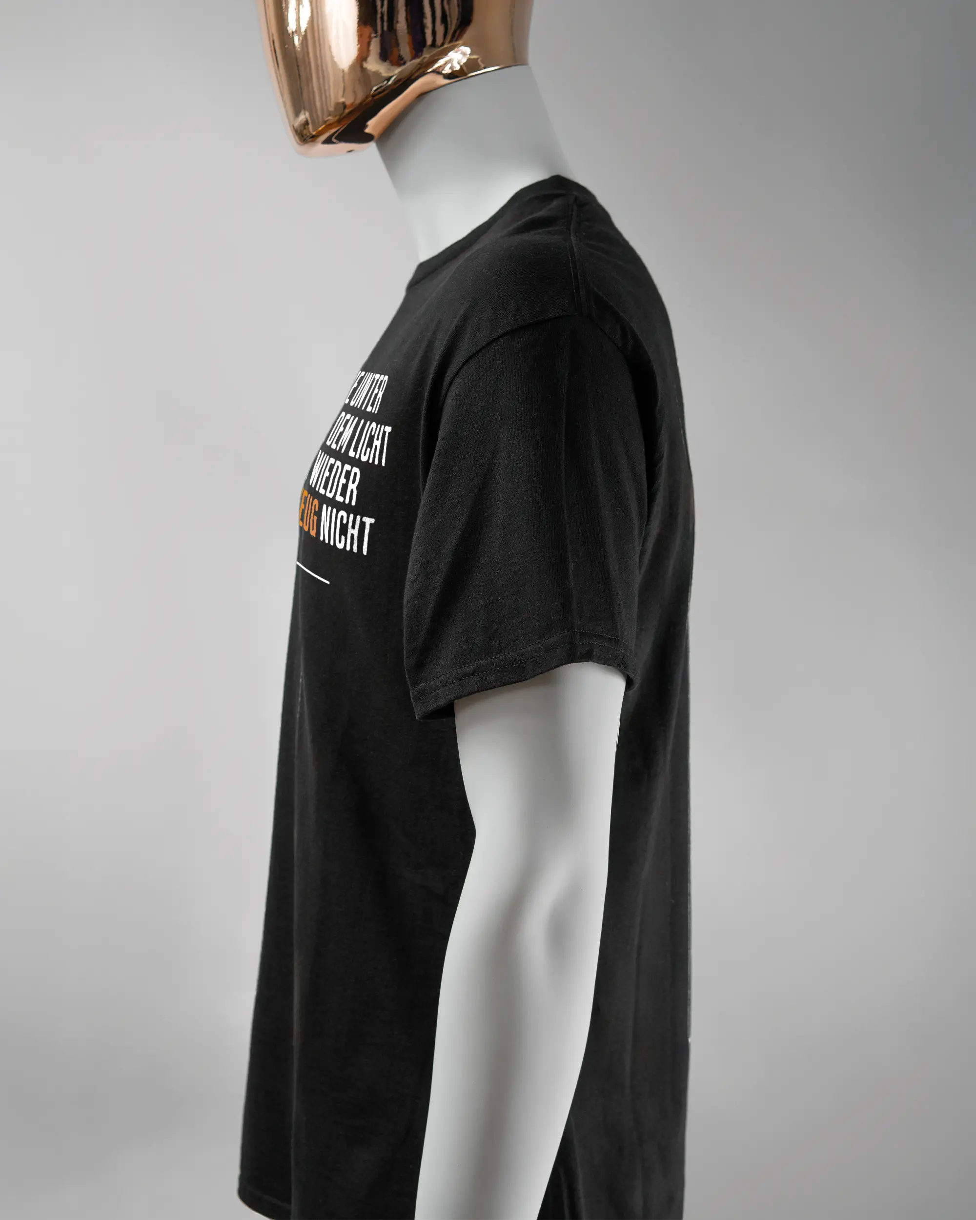 Seitenansicht des Basic Unisex T-Shirt Regular von Maondo mit dem Design Wegzeug vorne in der Farbe Black und in der Größe L getragen von einer maskulinen Puppe