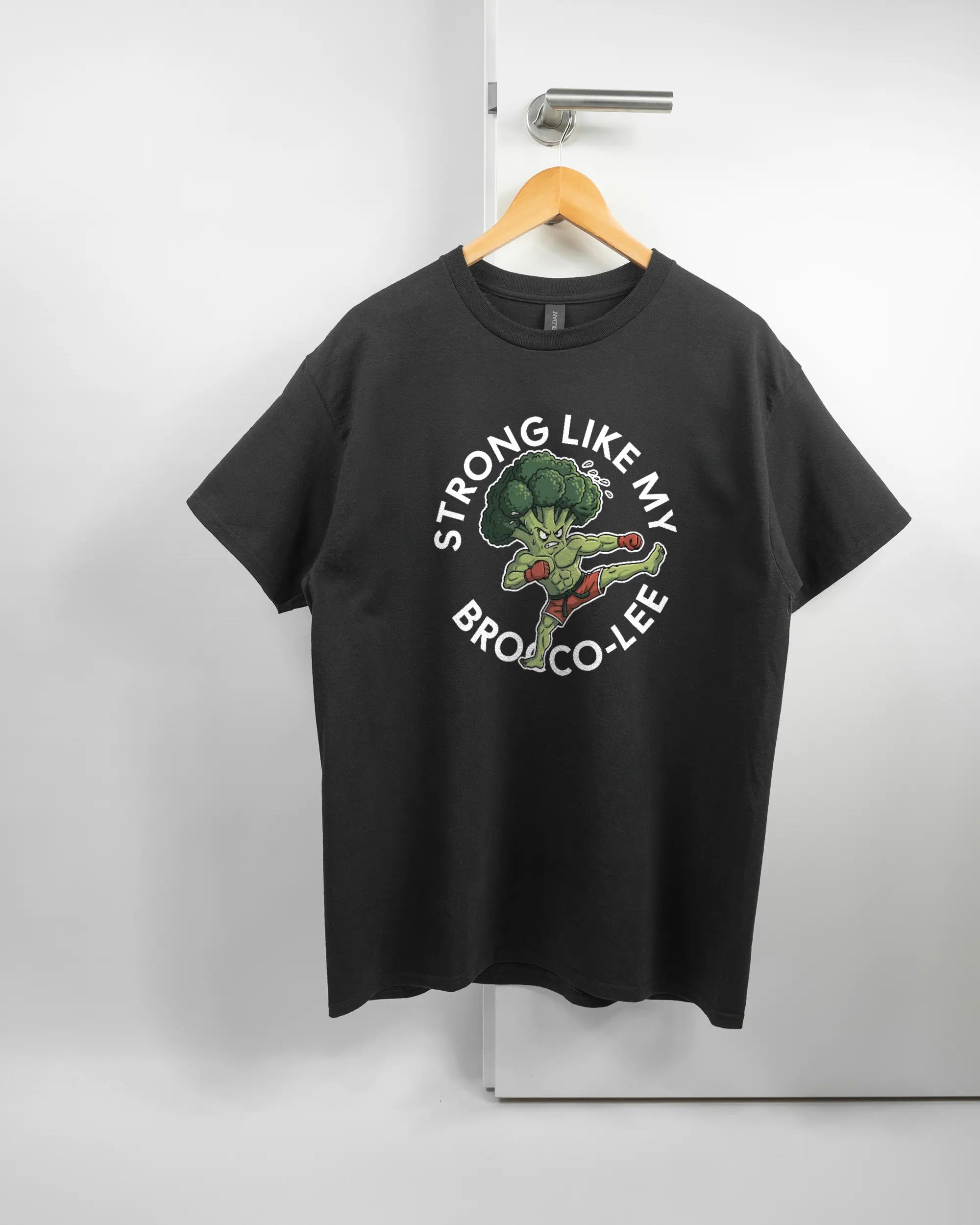 Vorderseite des Basic Unisex T-Shirt Regular von Maondo mit dem Design Brocco-Lee in der Farbe Black und in der Größe L auf einem Bügel an der Türklinke aufgehängt