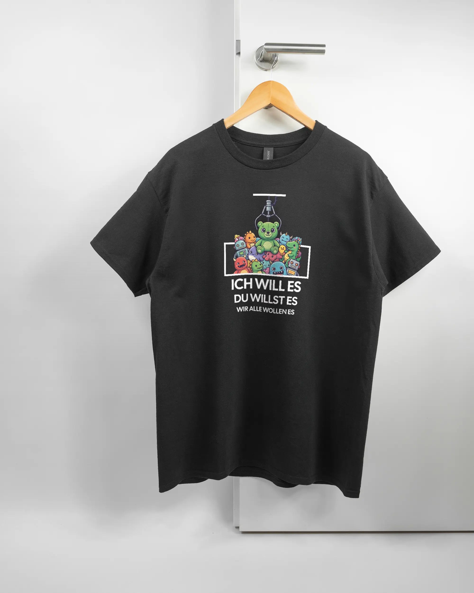 Vorderseite des Basic Unisex T-Shirt Regular von Maondo mit dem Design Will Stofftier in der Farbe Black und in der Größe L auf einem Bügel an der Türklinke aufgehängt