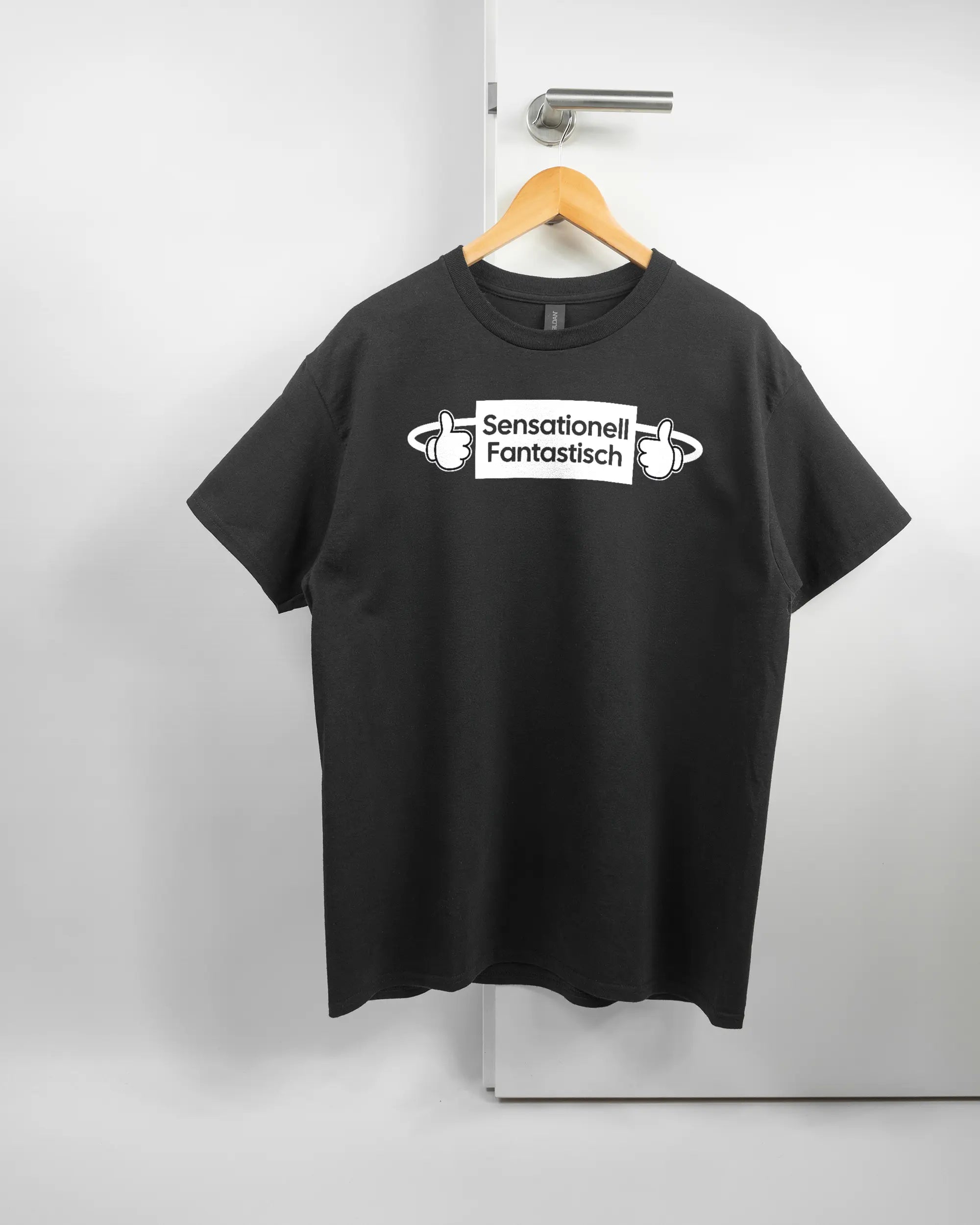 Vorderseite des Basic Unisex T-Shirt Regular von Maondo mit dem Design Fantastisch in der Farbe Black und in der Größe L auf einem Bügel an der Türklinke aufgehängt