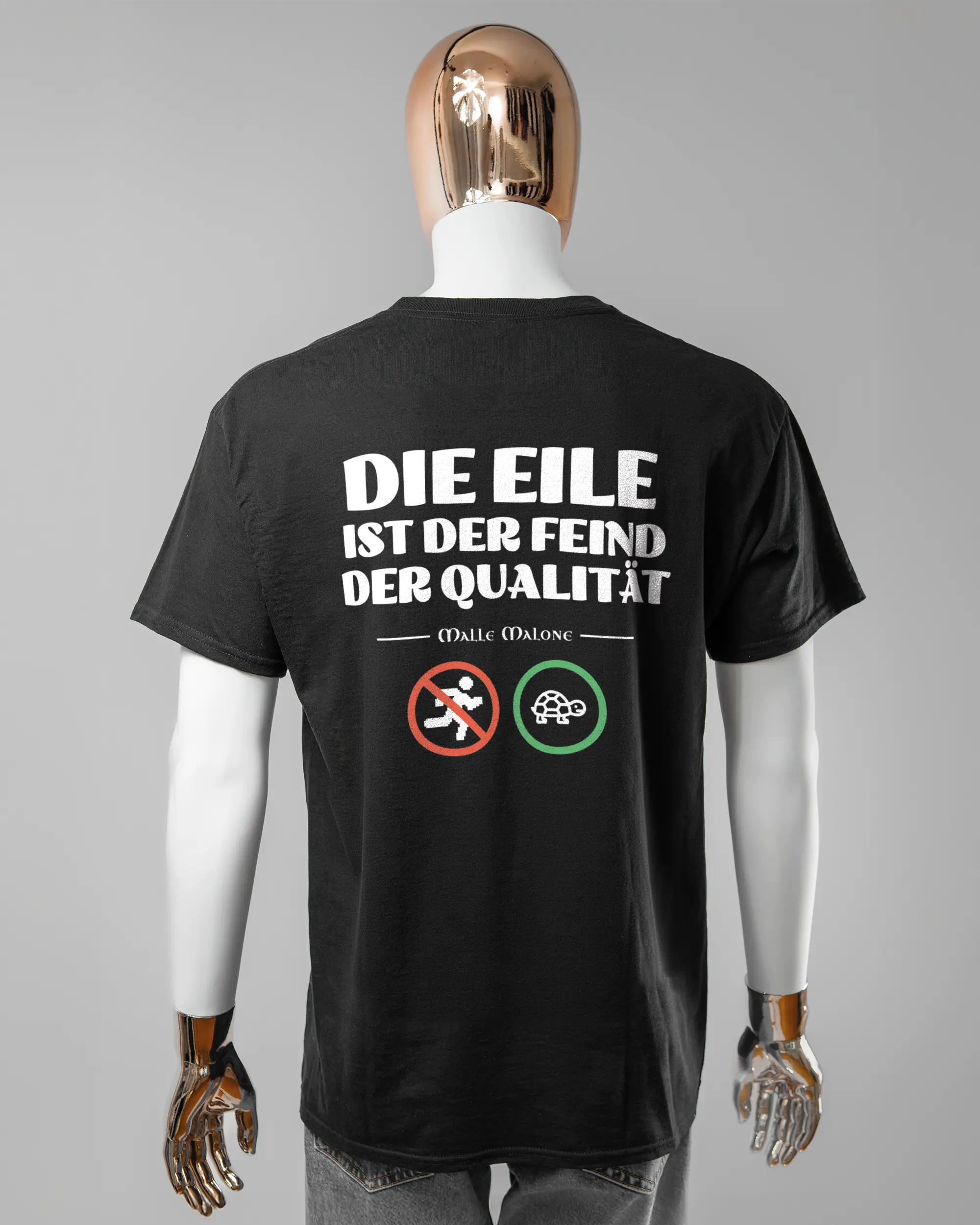 Rückseite des Basic Unisex T-Shirt Regular von Maondo mit dem Design Keine Eile in der Farbe Black und in der Größe L getragen von einer maskulinen Puppe