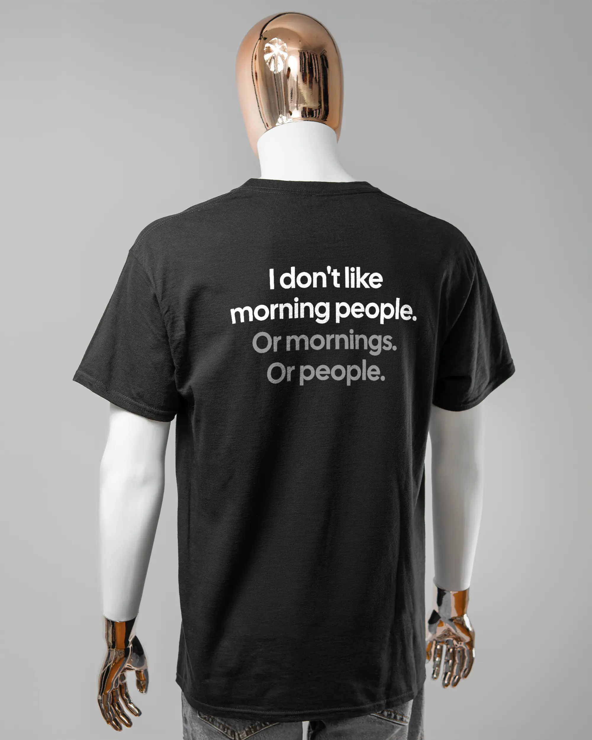 Rückseite des Basic Unisex T-Shirt Regular von Maondo mit dem Design Morning Person in der Farbe Black und in der Größe L getragen von einer maskulinen Puppe