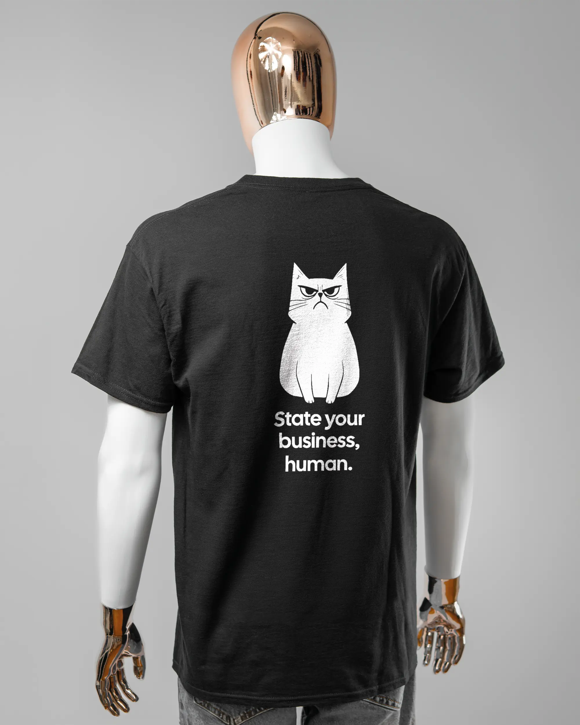 Rückseite des Basic Unisex T-Shirt Regular von Maondo mit dem Design Grumpy Purr in der Farbe Black und in der Größe L getragen von einer maskulinen Puppe