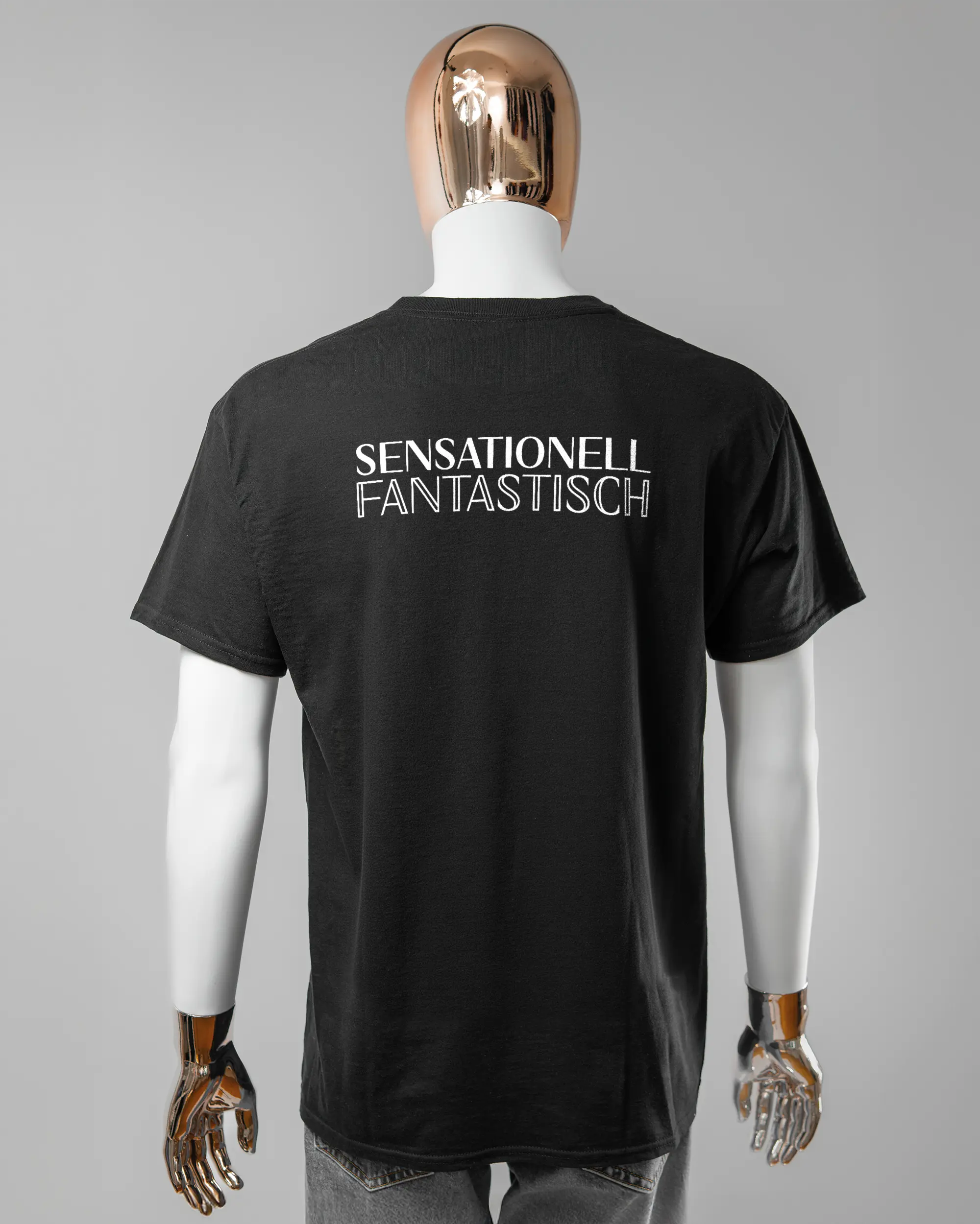 Rückseite des Basic Unisex T-Shirt Regular von Maondo mit dem Design Sensationell in der Farbe Black und in der Größe L getragen von einer maskulinen Puppe