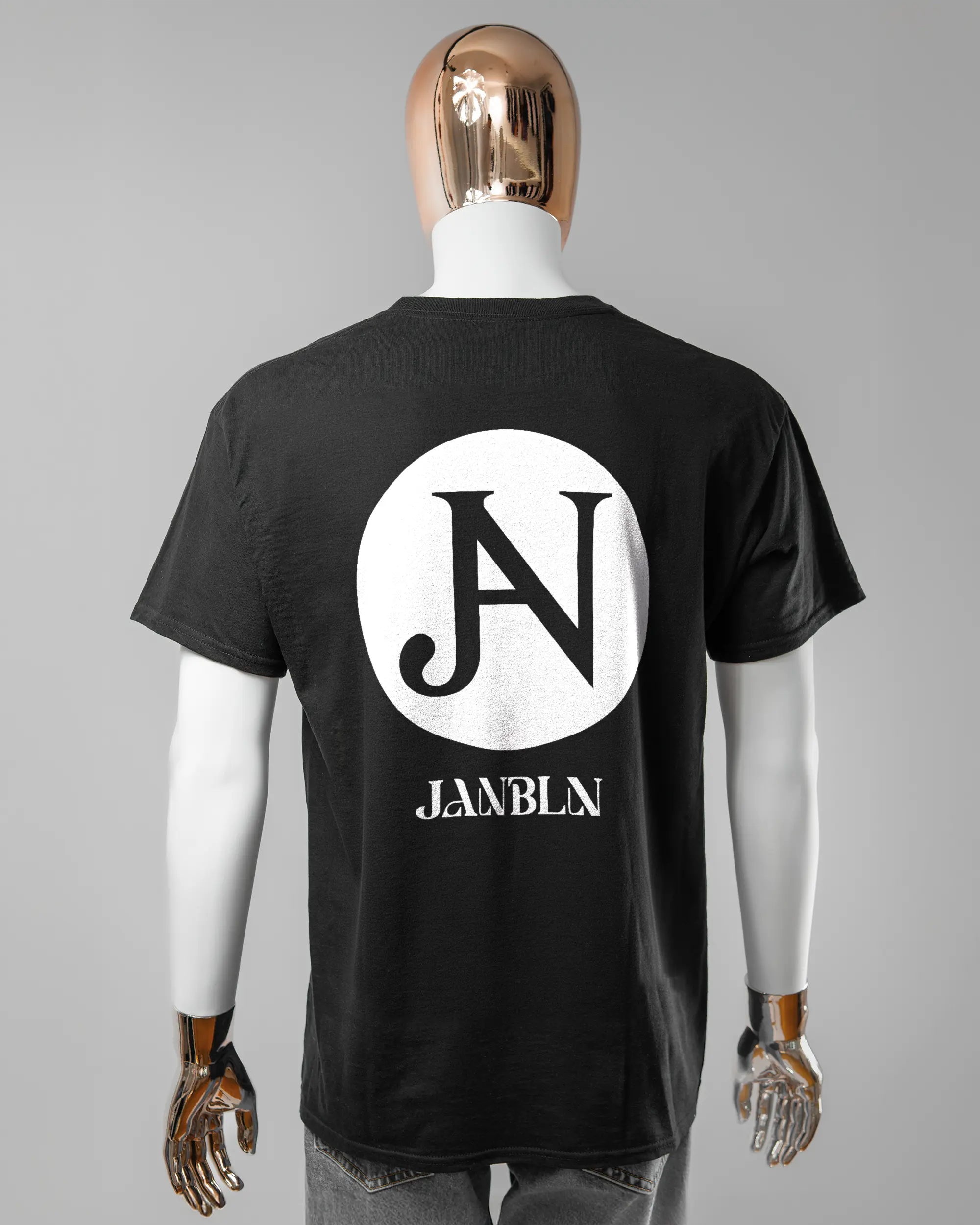 Rückseite des Basic Unisex T-Shirt Regular von Maondo mit dem Design JB1 in der Farbe Black und in der Größe L getragen von einer maskulinen Puppe