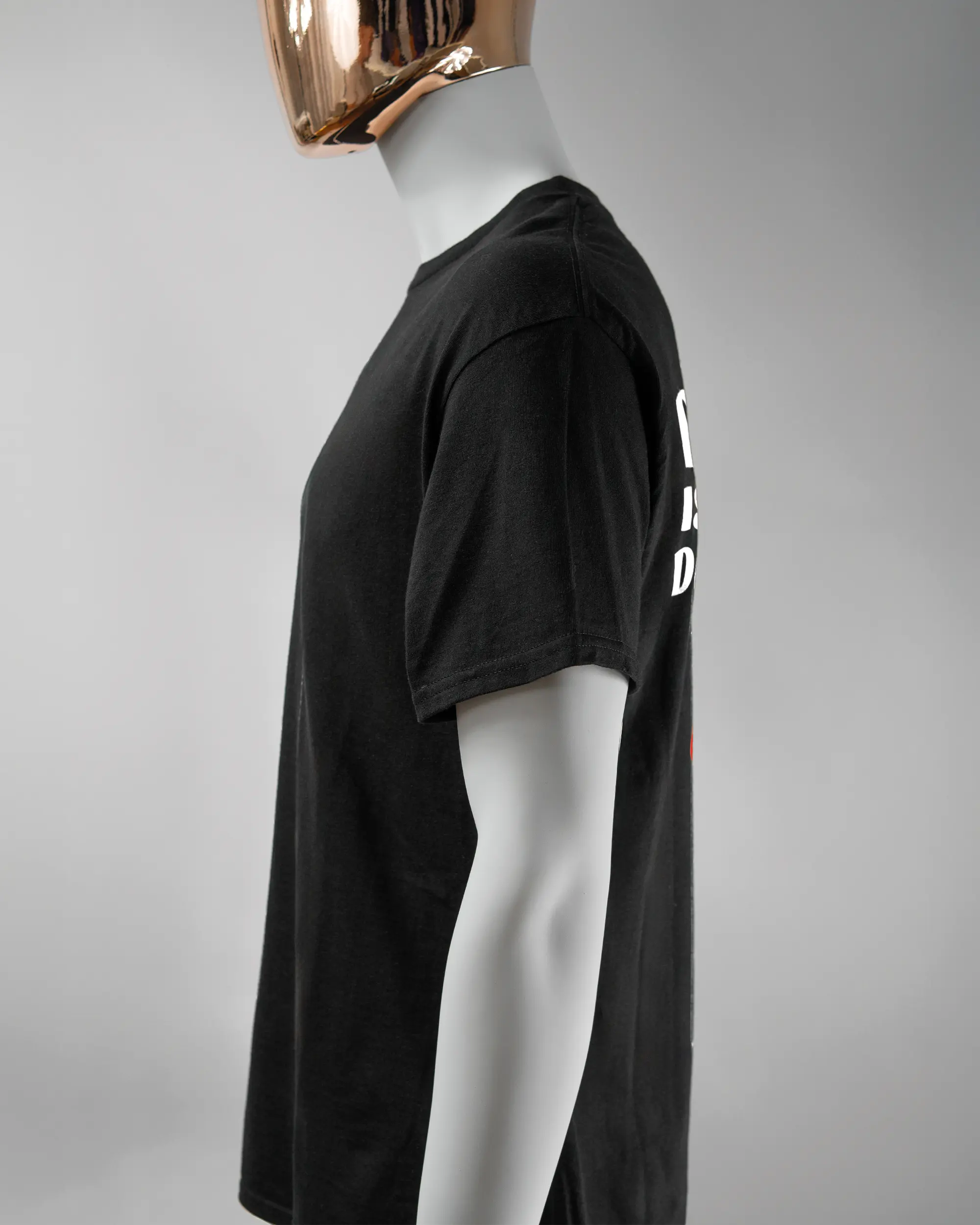 Seitenansicht des Basic Unisex T-Shirt Regular von Maondo mit dem Design Keine Eile hinten in der Farbe Black und in der Größe L getragen von einer maskulinen Puppe