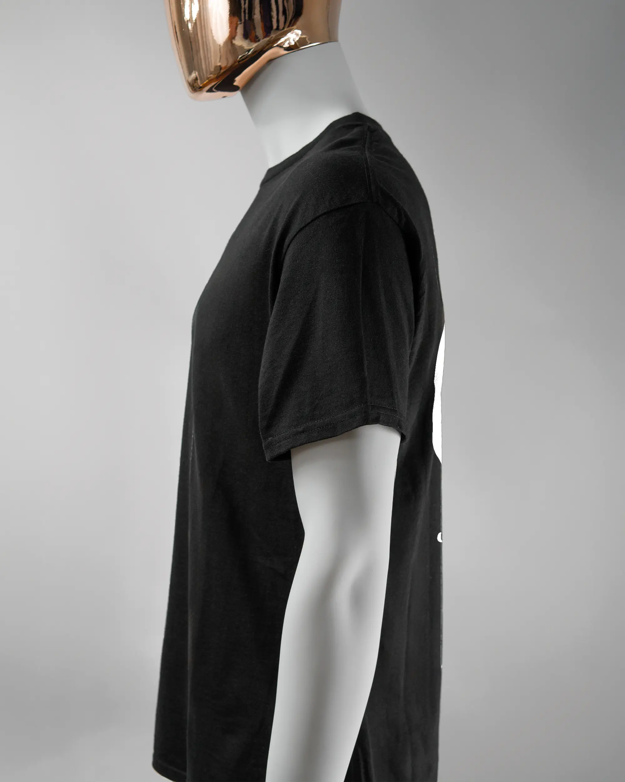 Seitenansicht des Basic Unisex T-Shirt Regular von Maondo mit dem Design JB1 hinten in der Farbe Black und in der Größe L getragen von einer maskulinen Puppe