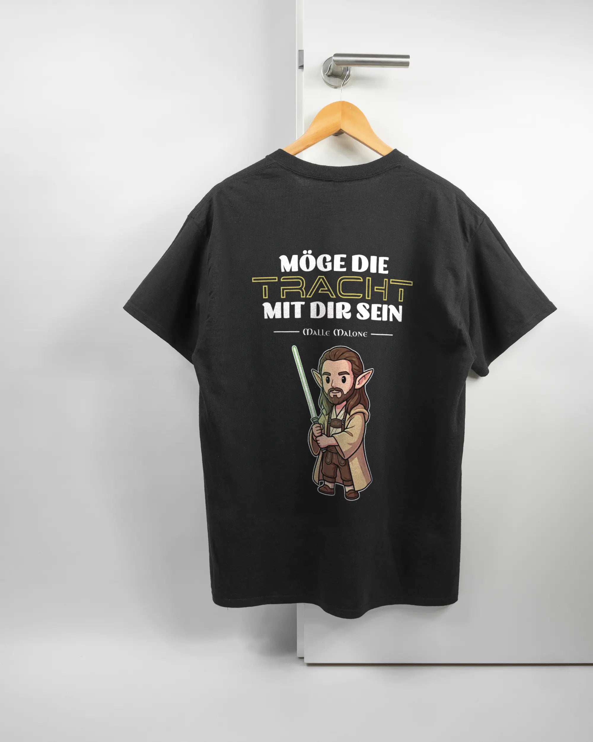 Rückseite des Basic Unisex T-Shirt Regular von Maondo mit dem Design Tracht mit dir in der Farbe Black und in der Größe L auf einem Bügel an der Türklinke aufgehängt