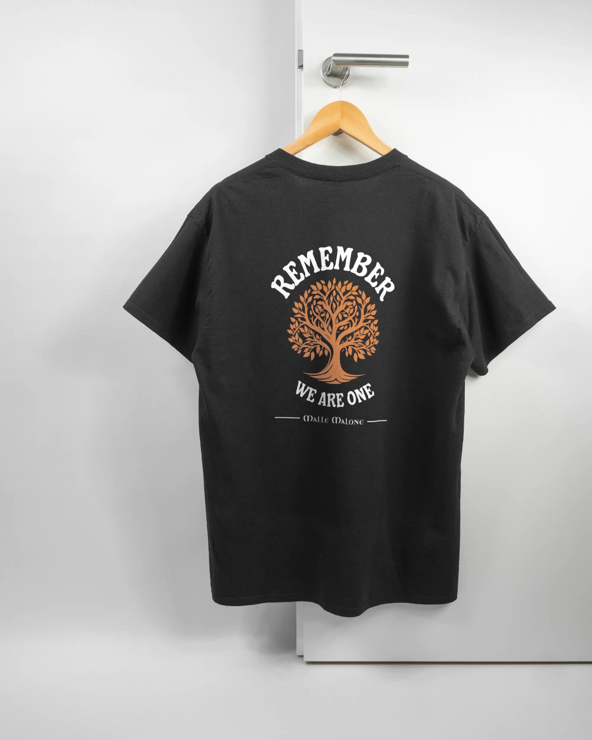 Rückseite des Basic Unisex T-Shirt Regular von Maondo mit dem Design We are one in der Farbe Black und in der Größe L auf einem Bügel an der Türklinke aufgehängt