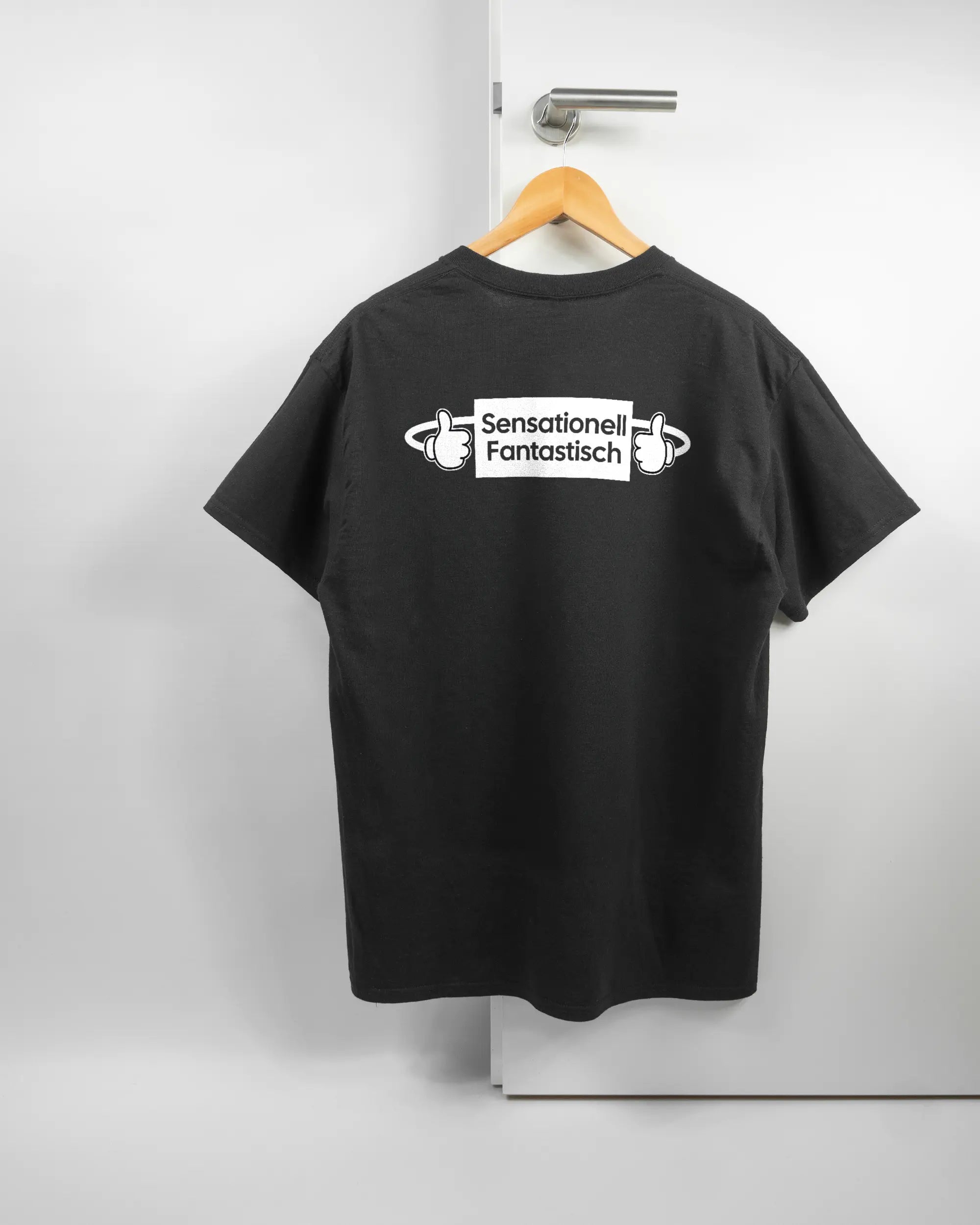 Rückseite des Basic Unisex T-Shirt Regular von Maondo mit dem Design Fantastisch in der Farbe Black und in der Größe L auf einem Bügel an der Türklinke aufgehängt