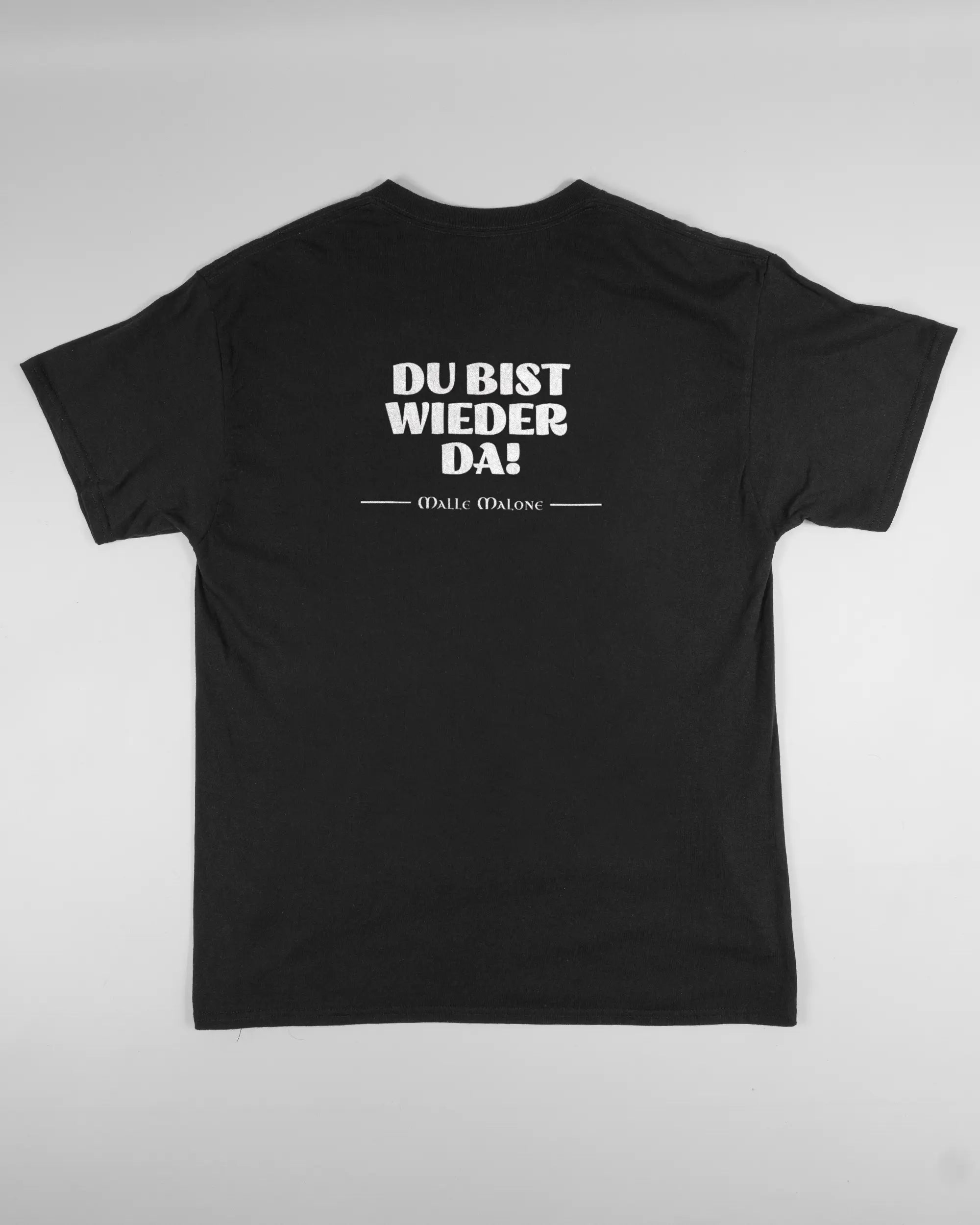 Rückseite des Basic Unisex T-Shirt Regular von Maondo mit dem Design Wieder da in der Farbe Black und in der Größe L flach auf den Boden gelegt