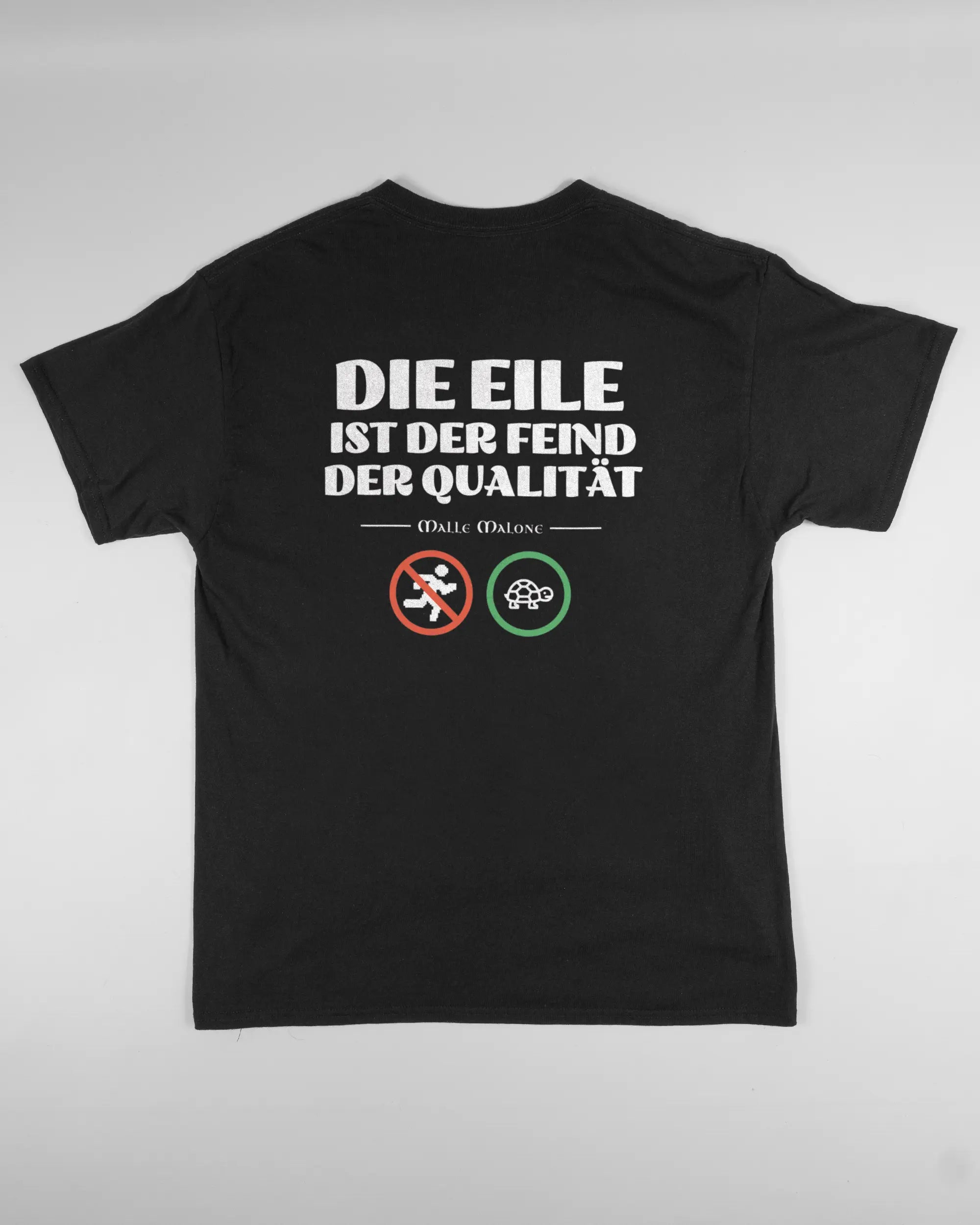 Rückseite des Basic Unisex T-Shirt Regular von Maondo mit dem Design Keine Eile in der Farbe Black und in der Größe L flach auf den Boden gelegt