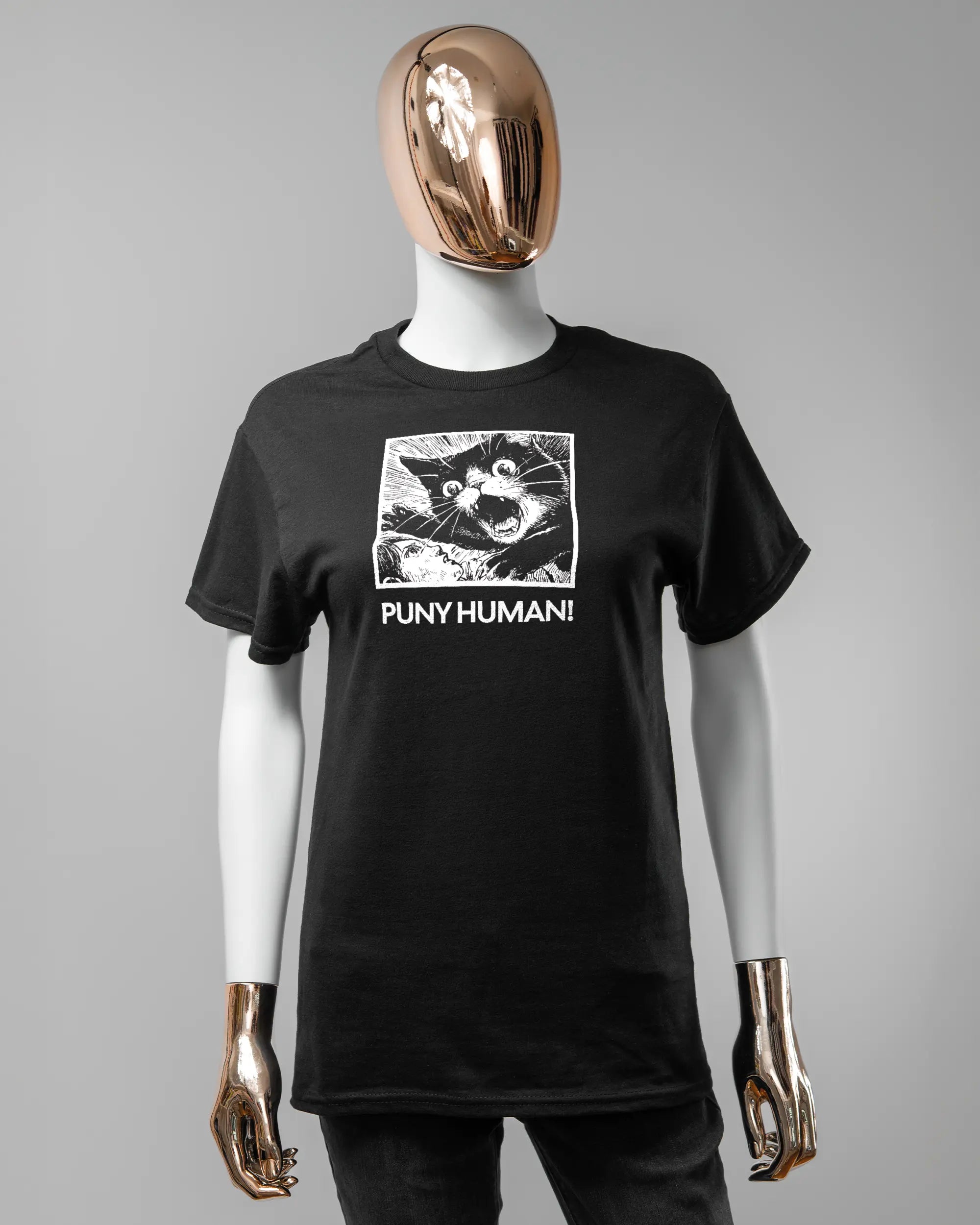 Vorderseite des Basic Unisex T-Shirt Regular von Maondo mit dem Design Puny Human in der Farbe Black und in der Größe S getragen von einer femininen Puppe