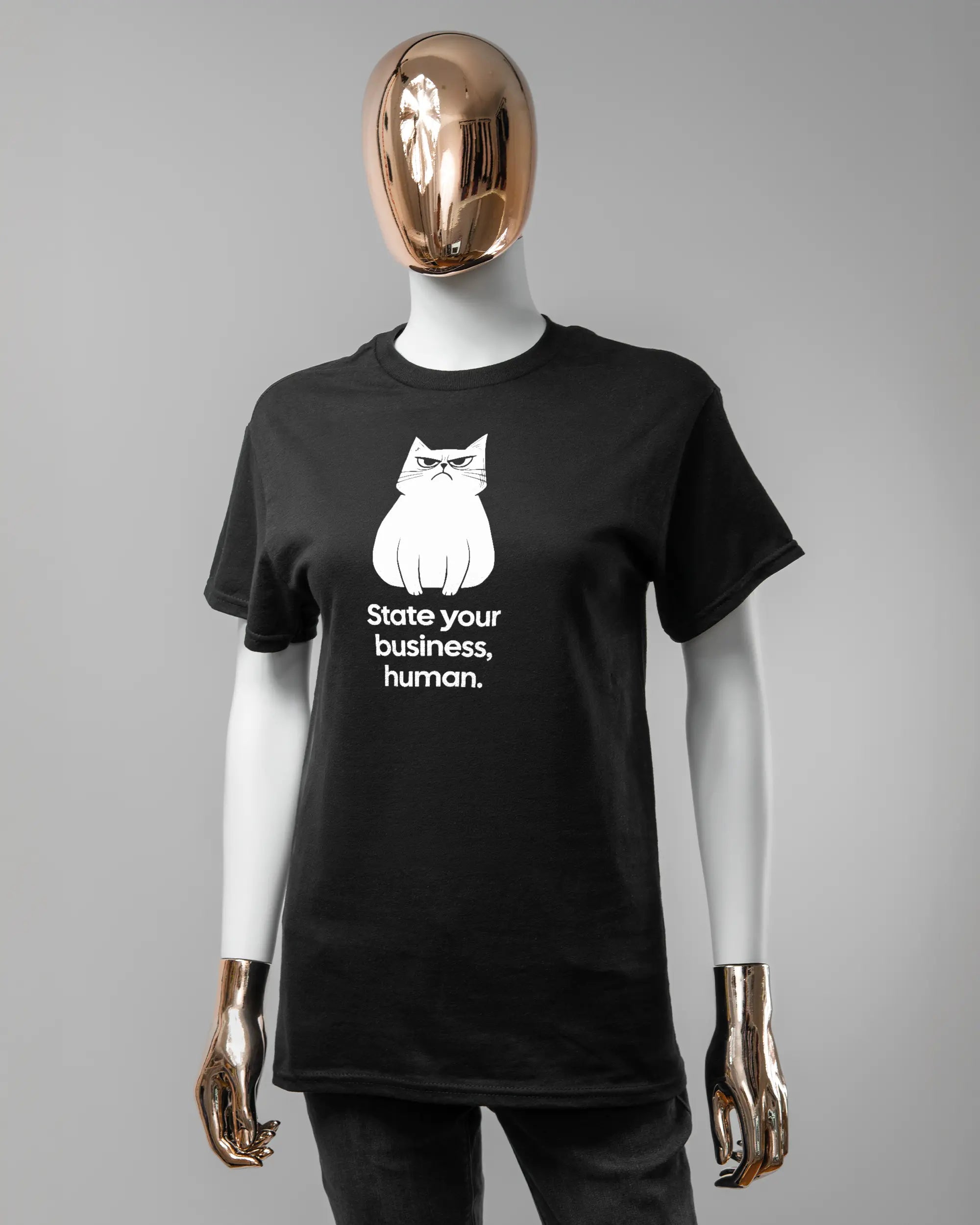 Vorderseite des Basic Unisex T-Shirt Regular von Maondo mit dem Design Grumpy Purr in der Farbe Black und in der Größe S getragen von einer femininen Puppe