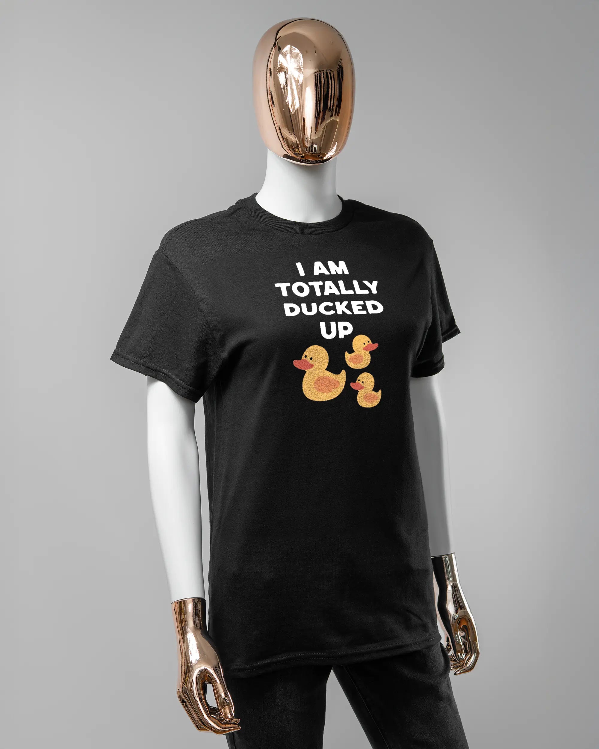 Vorderseite des Basic Unisex T-Shirt Regular von Maondo mit dem Design Ducked Up in der Farbe Black und in der Größe S getragen von einer femininen Puppe