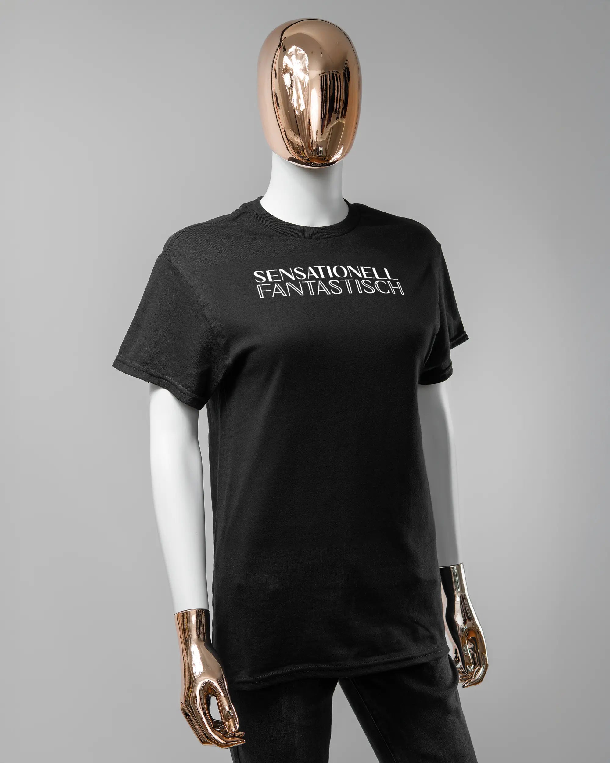 Vorderseite des Basic Unisex T-Shirt Regular von Maondo mit dem Design Sensationell in der Farbe Black und in der Größe S getragen von einer femininen Puppe
