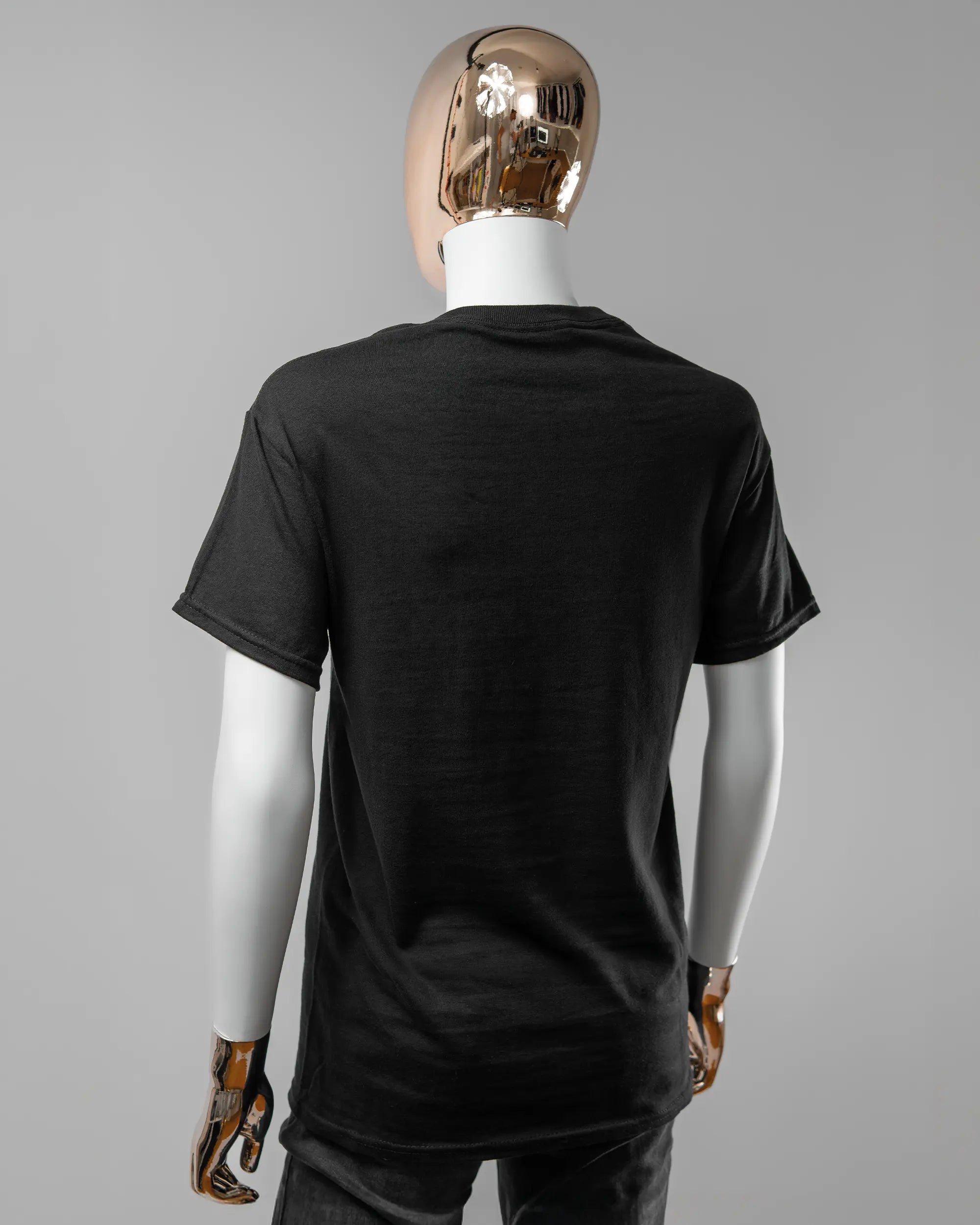 Rückseite des Basic Unisex T-Shirt Regular von Maondo ohne Motiv in der Farbe Black und in der Größe S getragen von einer femininen Puppe