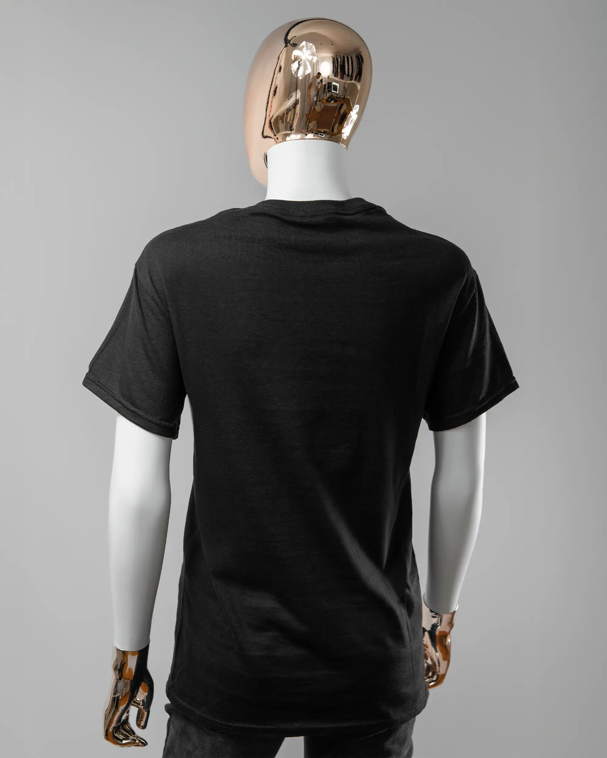 Rückseite des Basic Unisex T-Shirt Regular von Maondo ohne Motiv in der Farbe Black und in der Größe S getragen von einer femininen Puppe