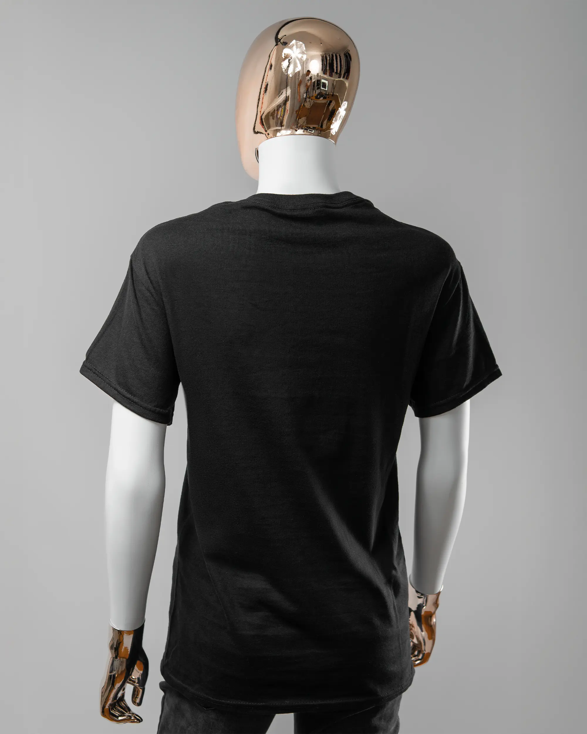 Rückseite des Basic Unisex T-Shirt Regular von Maondo ohne Motiv in der Farbe Black und in der Größe S getragen von einer femininen Puppe