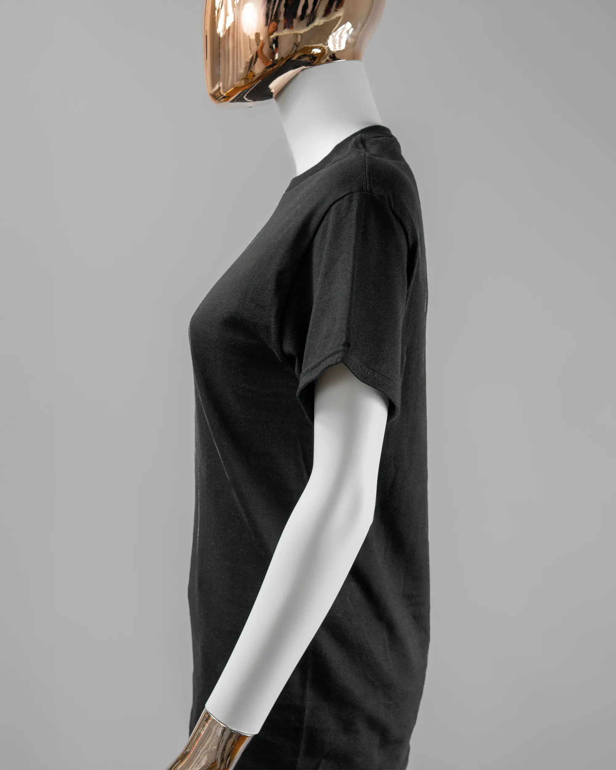 Seitenansicht des Basic Unisex T-Shirt Regular von Maondo mit dem Design Eins nach dem Annern vorne in der Farbe Black und in der Größe S getragen von einer femininen Puppe