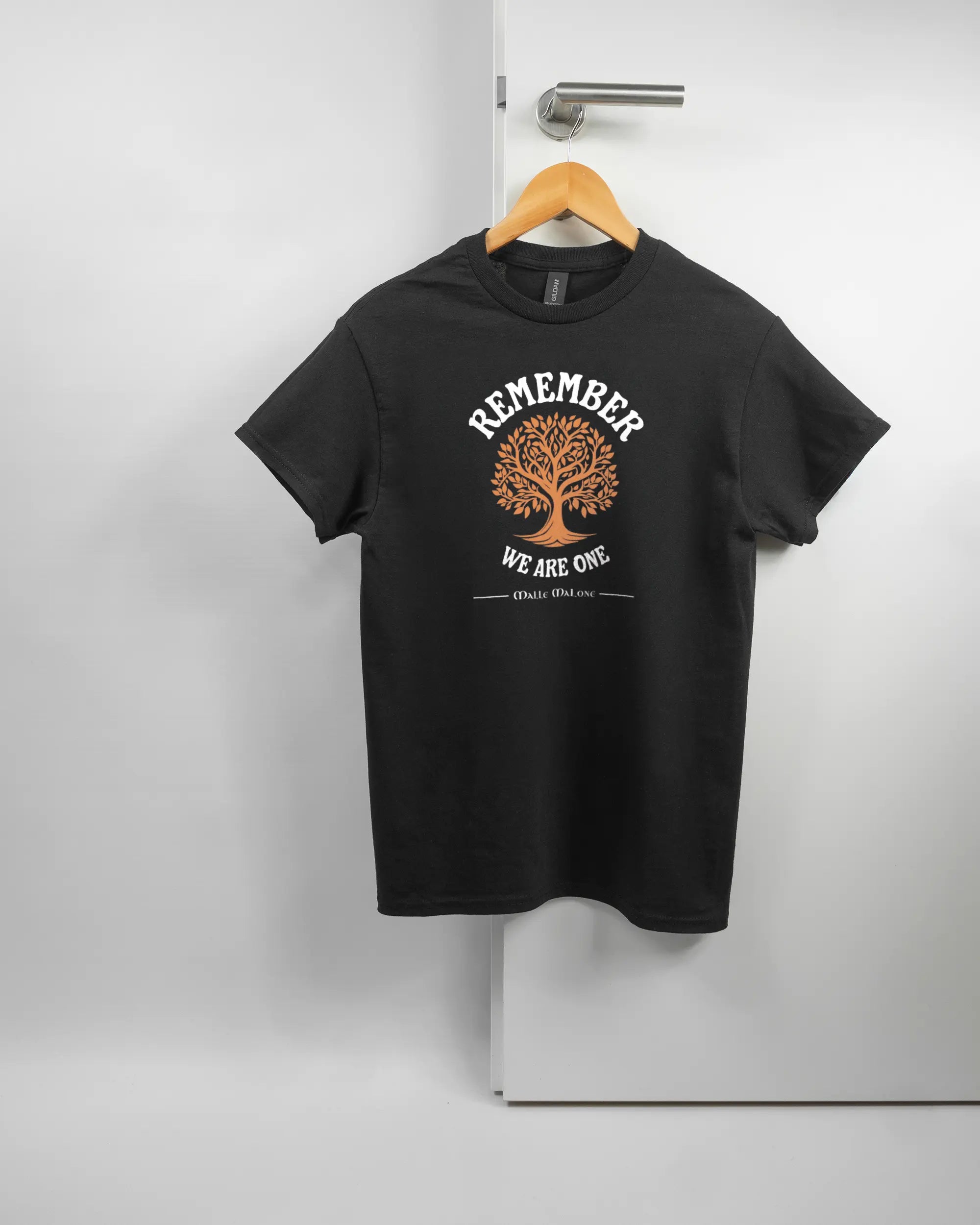 Vorderseite des Basic Unisex T-Shirt Regular von Maondo mit dem Design We are one in der Farbe Black und in der Größe S auf einem Bügel an der Türklinke aufgehängt