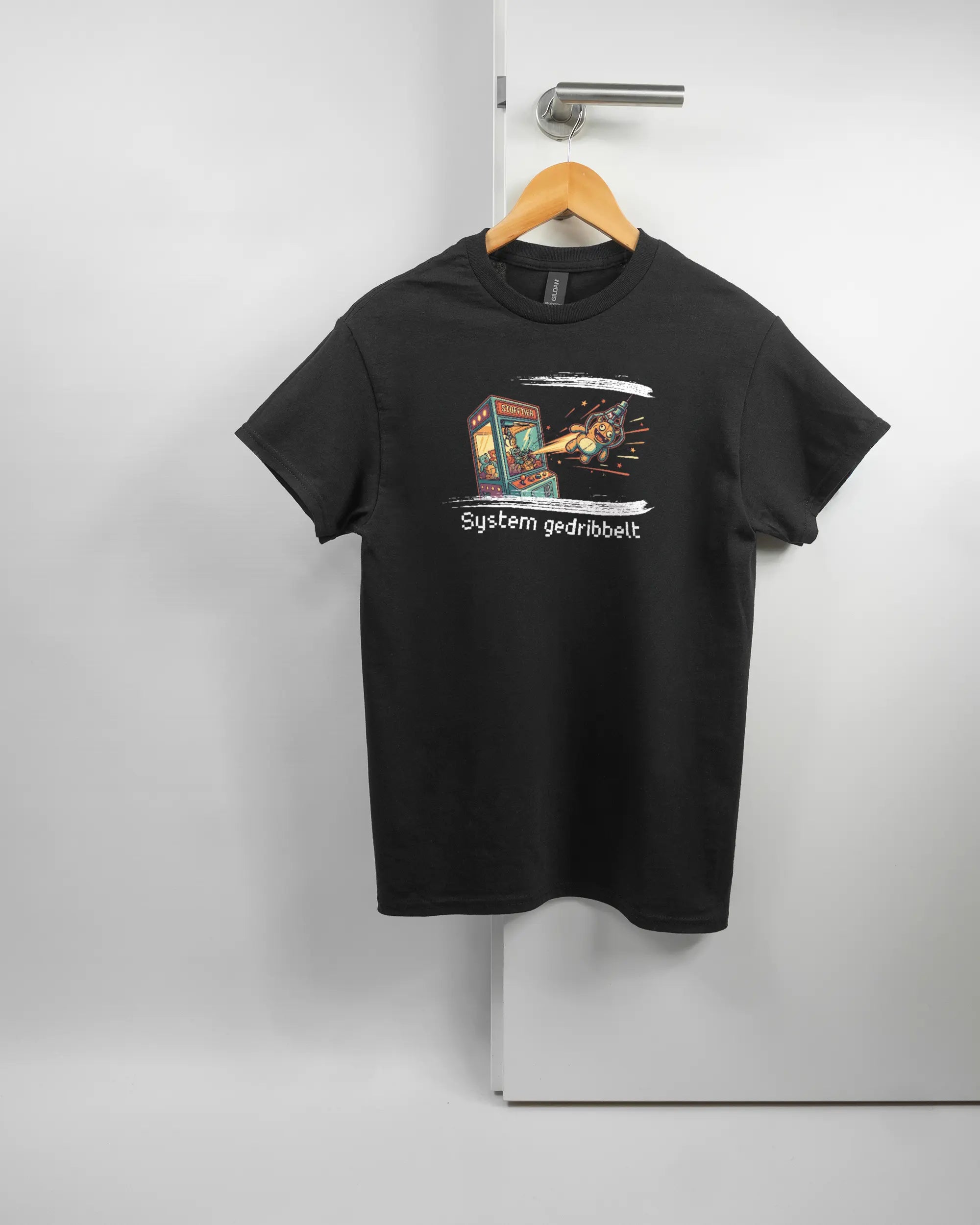 Vorderseite des Basic Unisex T-Shirt Regular von Maondo mit dem Design System gedribbelt in der Farbe Black und in der Größe S auf einem Bügel an der Türklinke aufgehängt