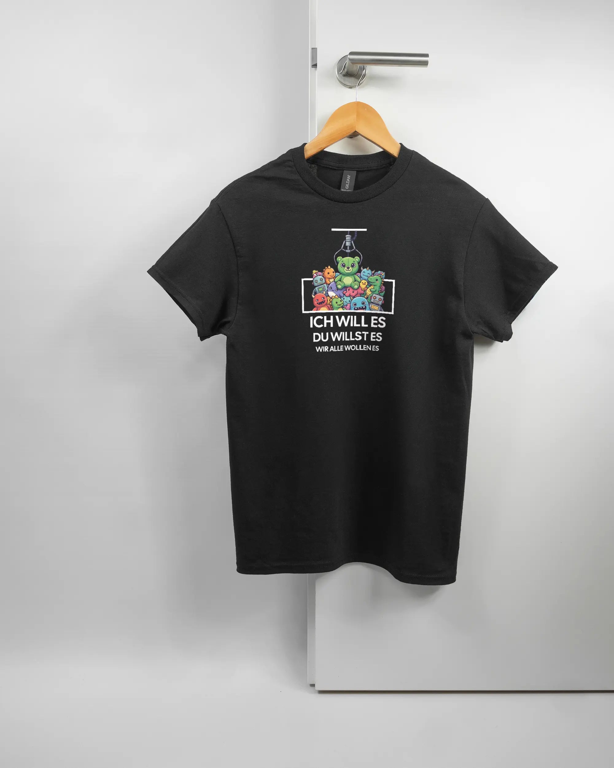 Vorderseite des Basic Unisex T-Shirt Regular von Maondo mit dem Design Will Stofftier in der Farbe Black und in der Größe S auf einem Bügel an der Türklinke aufgehängt