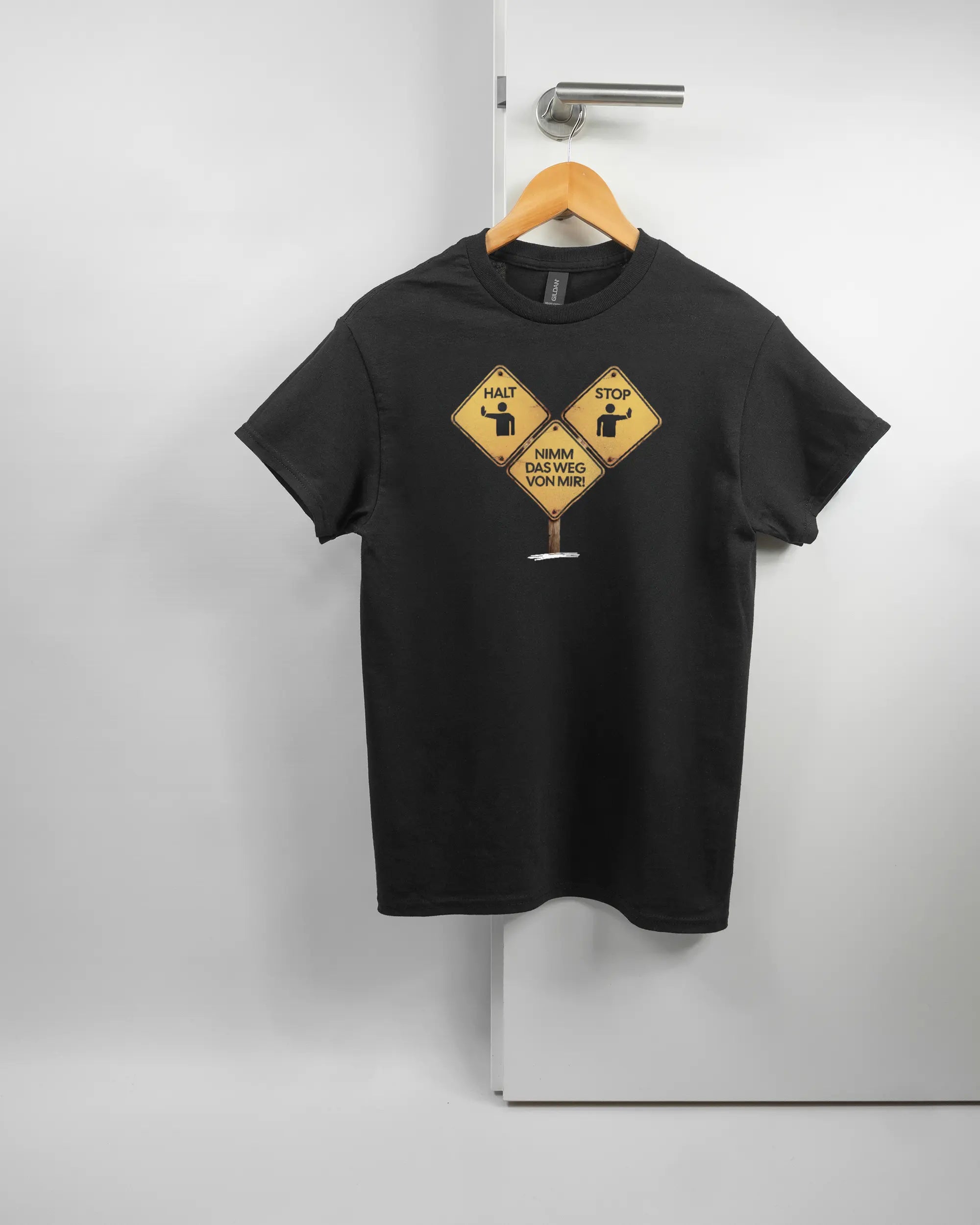 Vorderseite des Basic Unisex T-Shirt Regular von Maondo mit dem Design Schutzschild in der Farbe Black und in der Größe S auf einem Bügel an der Türklinke aufgehängt