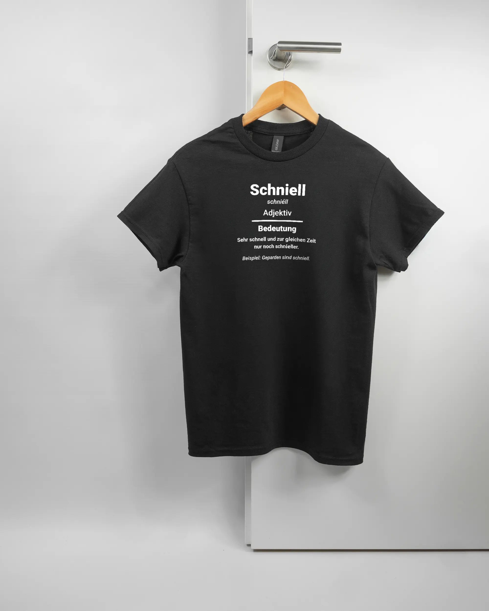 Vorderseite des Basic Unisex T-Shirt Regular von Maondo mit dem Design Schniell in der Farbe Black und in der Größe S auf einem Bügel an der Türklinke aufgehängt