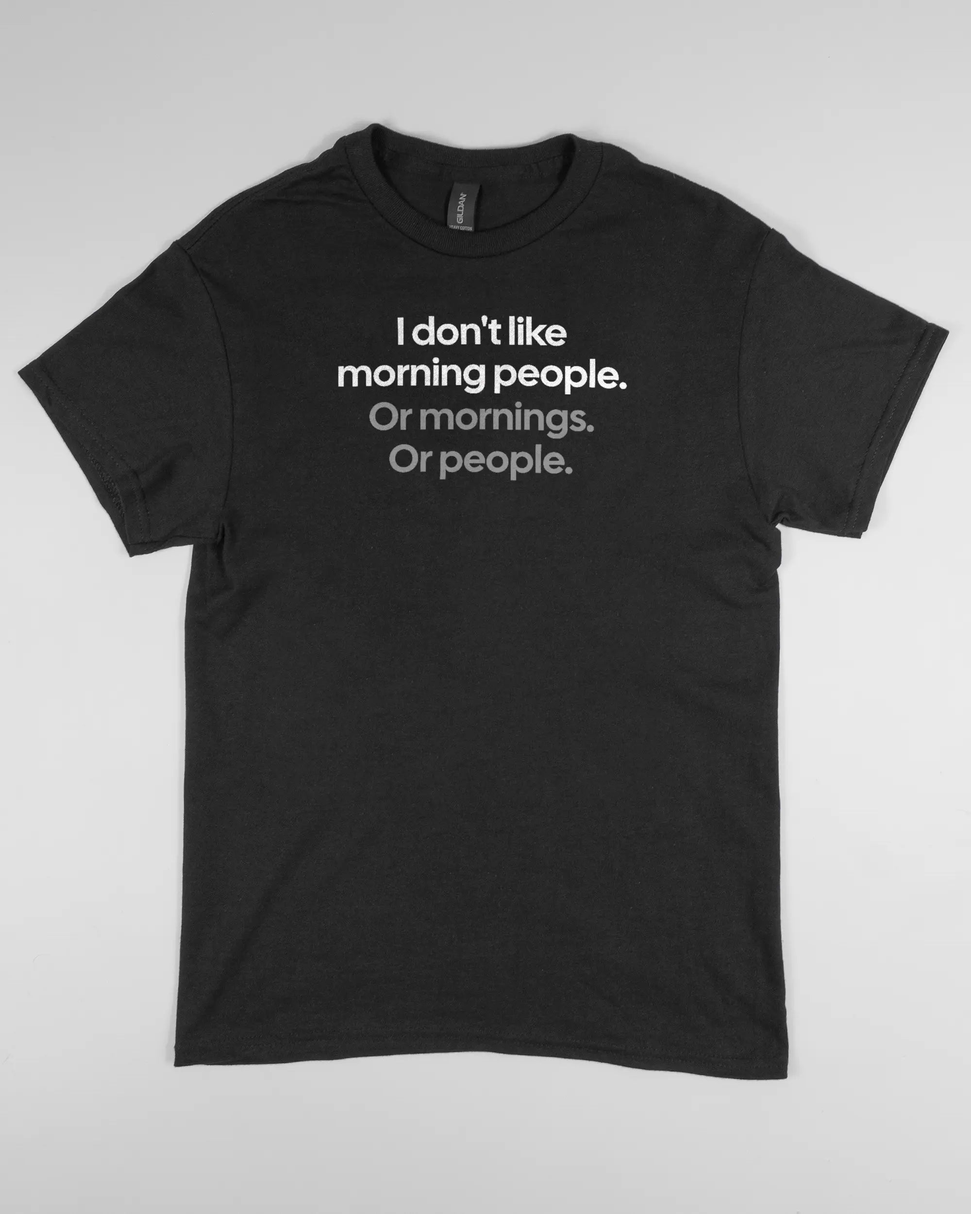 Vorderseite des Basic Unisex T-Shirt Regular von Maondo mit dem Design Morning Person in der Farbe Black und in der Größe S flach auf den Boden gelegt