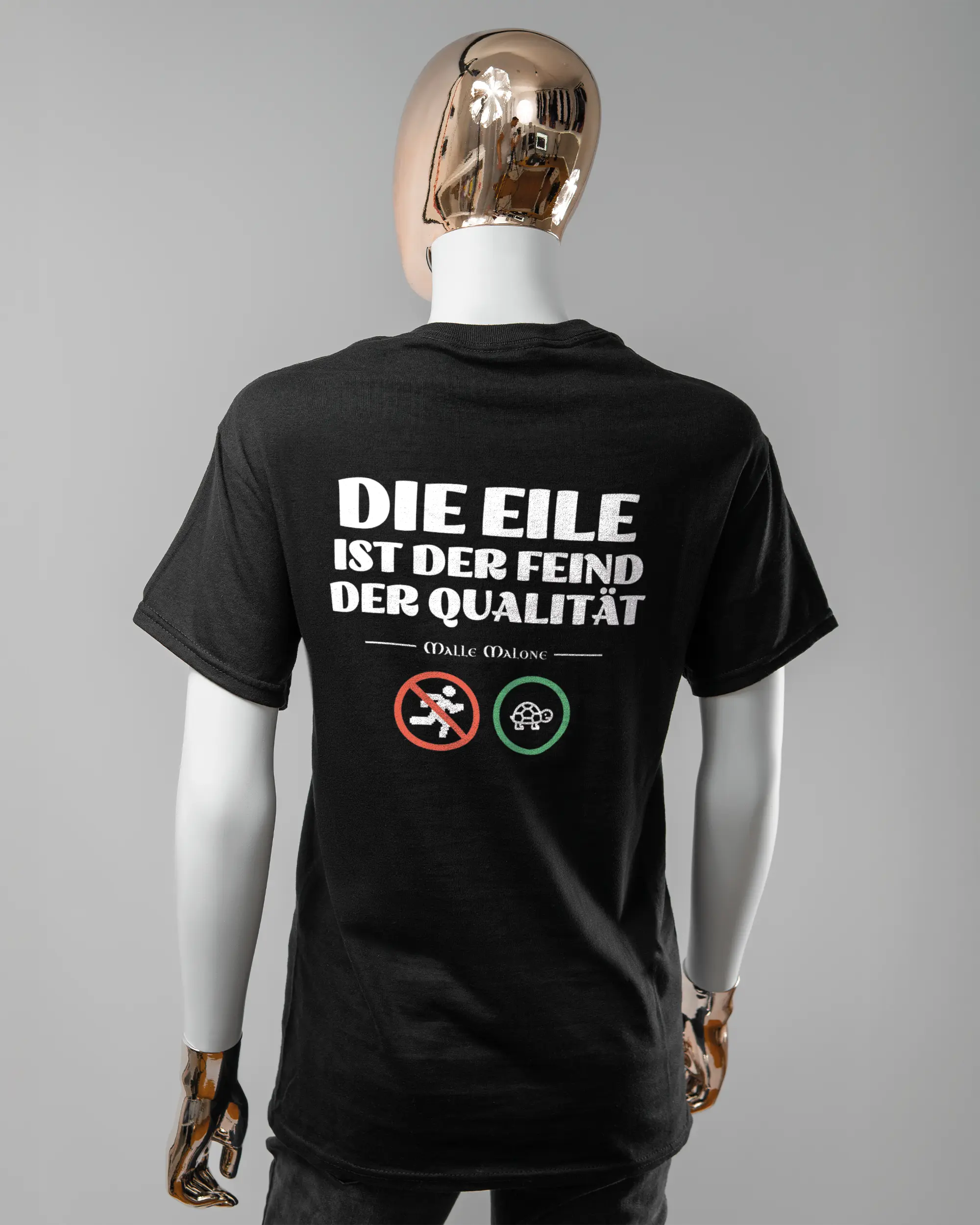 Rückseite des Basic Unisex T-Shirt Regular von Maondo mit dem Design Keine Eile in der Farbe Black und in der Größe S getragen von einer femininen Puppe
