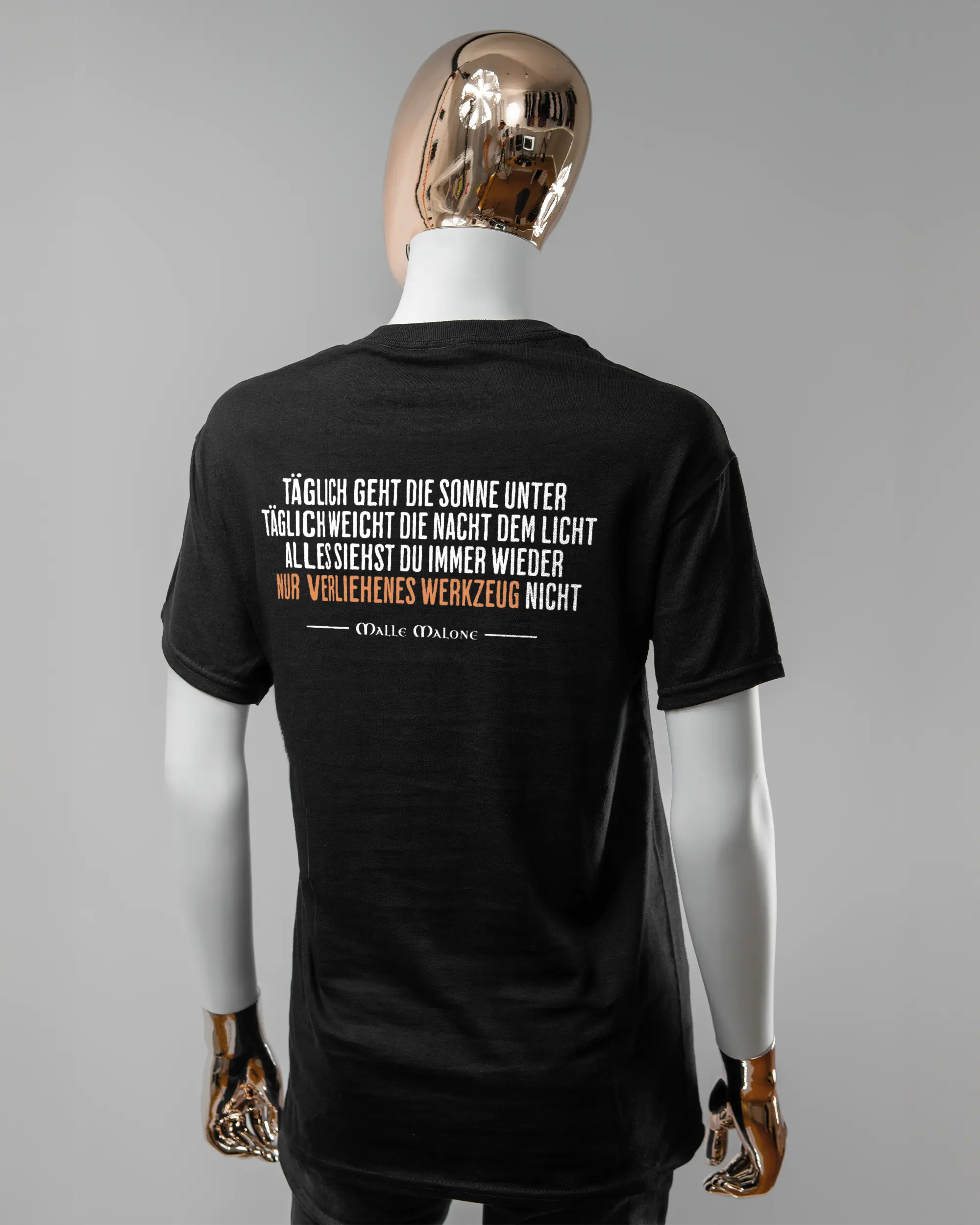Rückseite des Basic Unisex T-Shirt Regular von Maondo mit dem Design Wegzeug in der Farbe Black und in der Größe S getragen von einer femininen Puppe