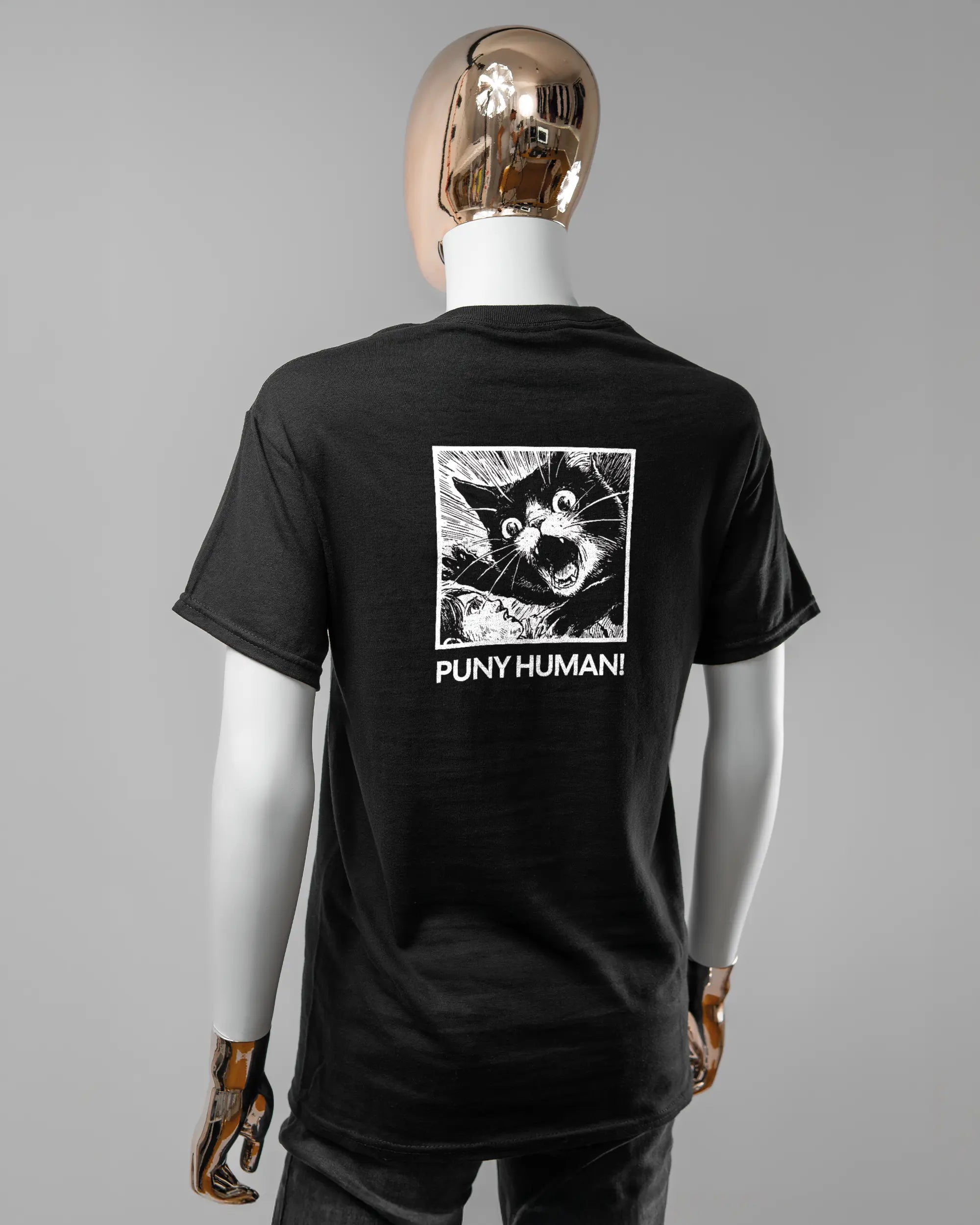 Rückseite des Basic Unisex T-Shirt Regular von Maondo mit dem Design Puny Human in der Farbe Black und in der Größe S getragen von einer femininen Puppe