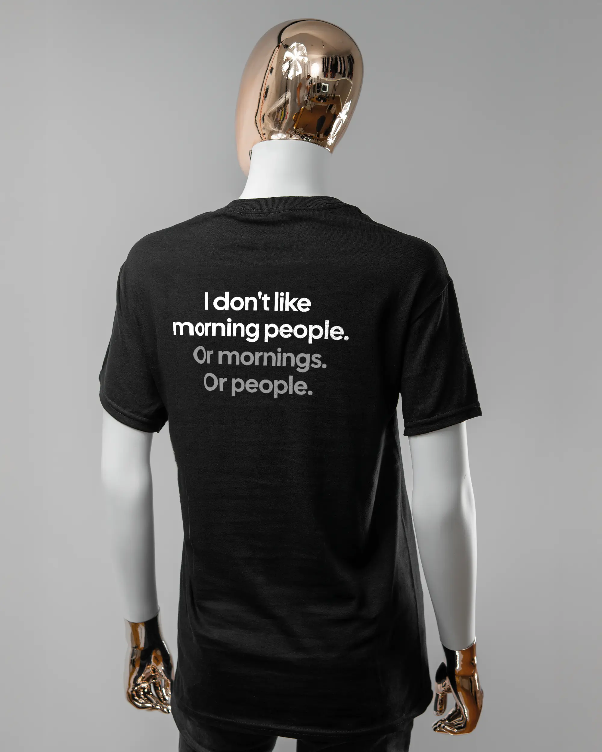 Rückseite des Basic Unisex T-Shirt Regular von Maondo mit dem Design Morning Person in der Farbe Black und in der Größe S getragen von einer femininen Puppe