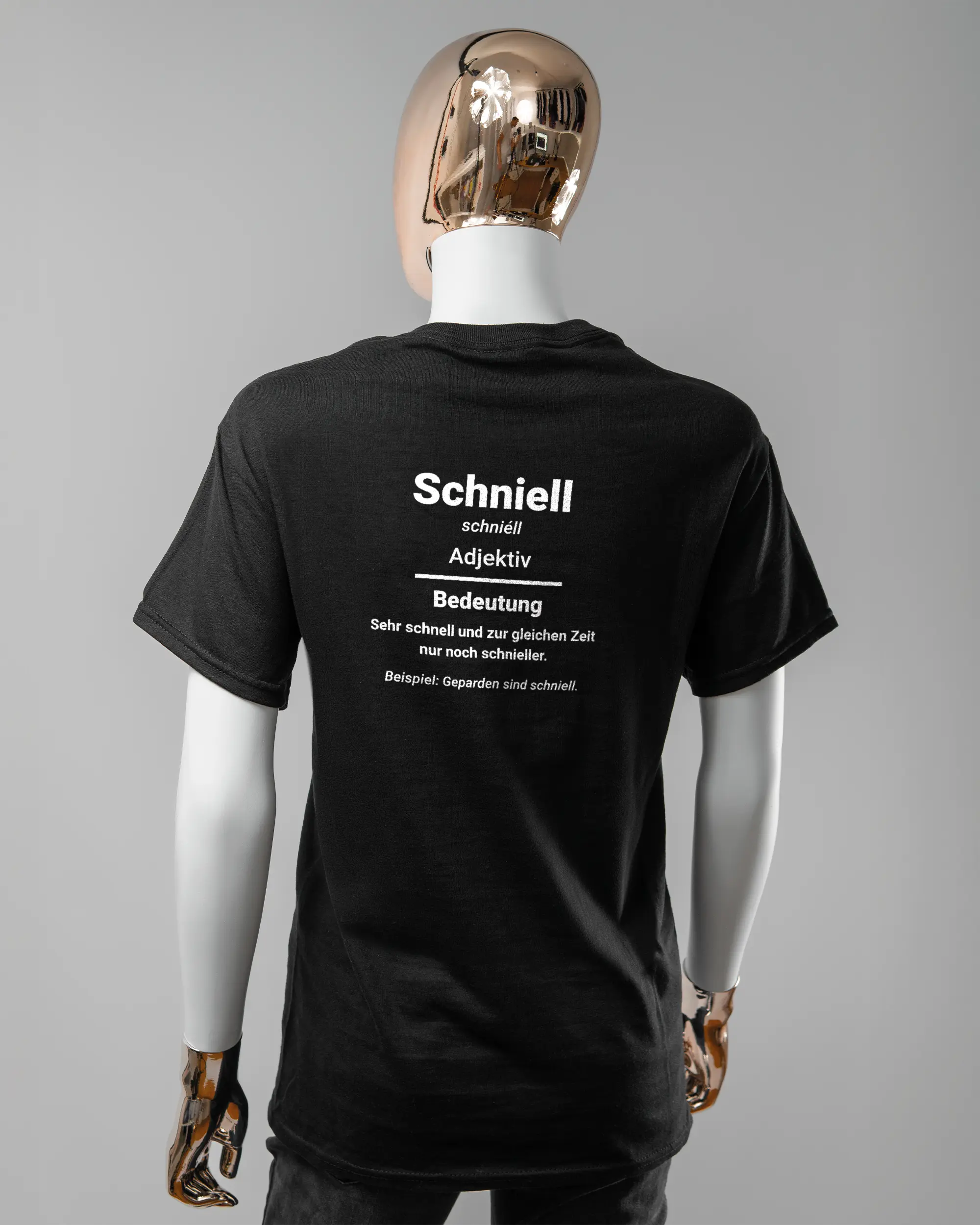 Rückseite des Basic Unisex T-Shirt Regular von Maondo mit dem Design Schniell in der Farbe Black und in der Größe S getragen von einer femininen Puppe