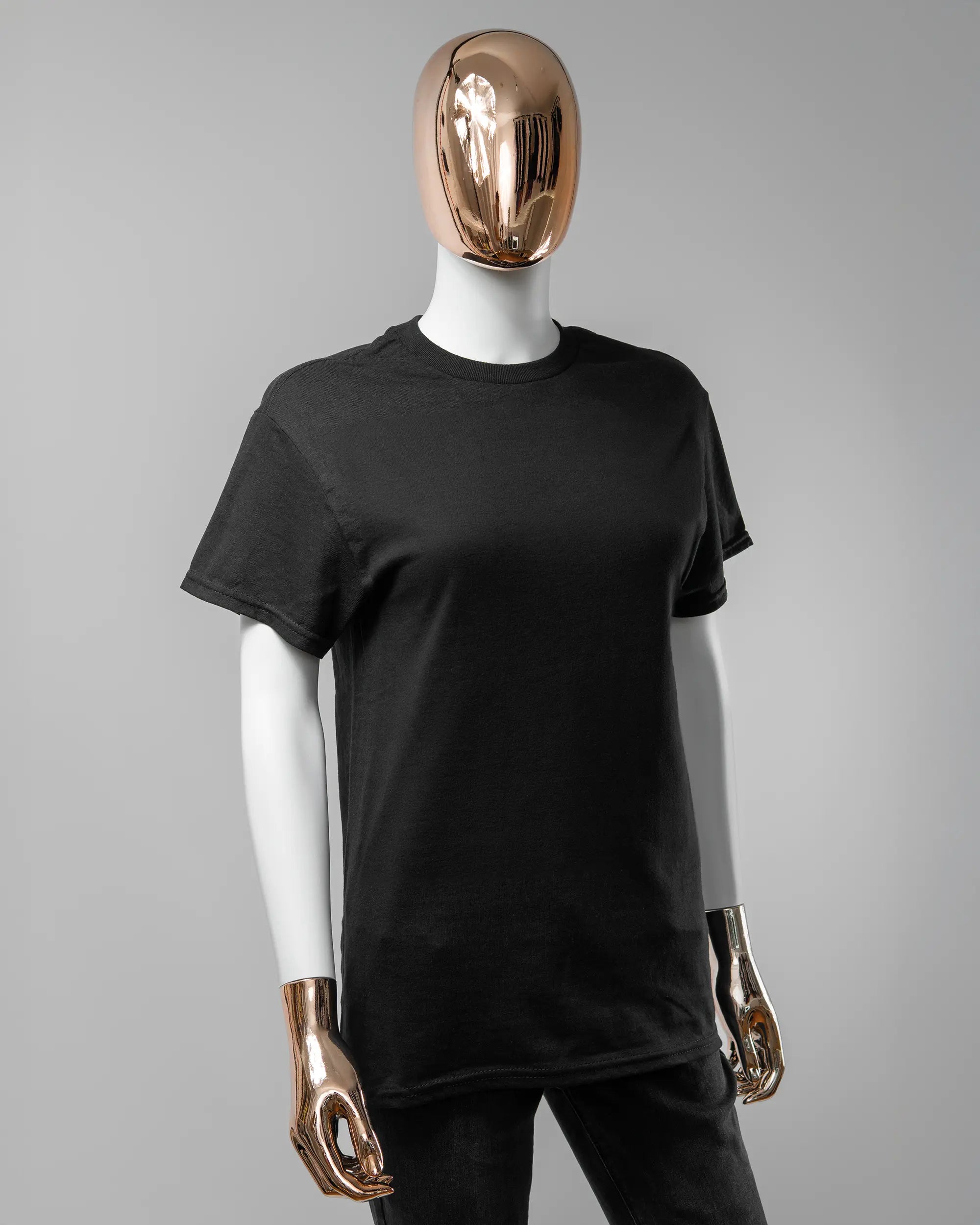 Vorderseite des Basic Unisex T-Shirt Regular von Maondo ohne Motiv in der Farbe Black und in der Größe S getragen von einer femininen Puppe