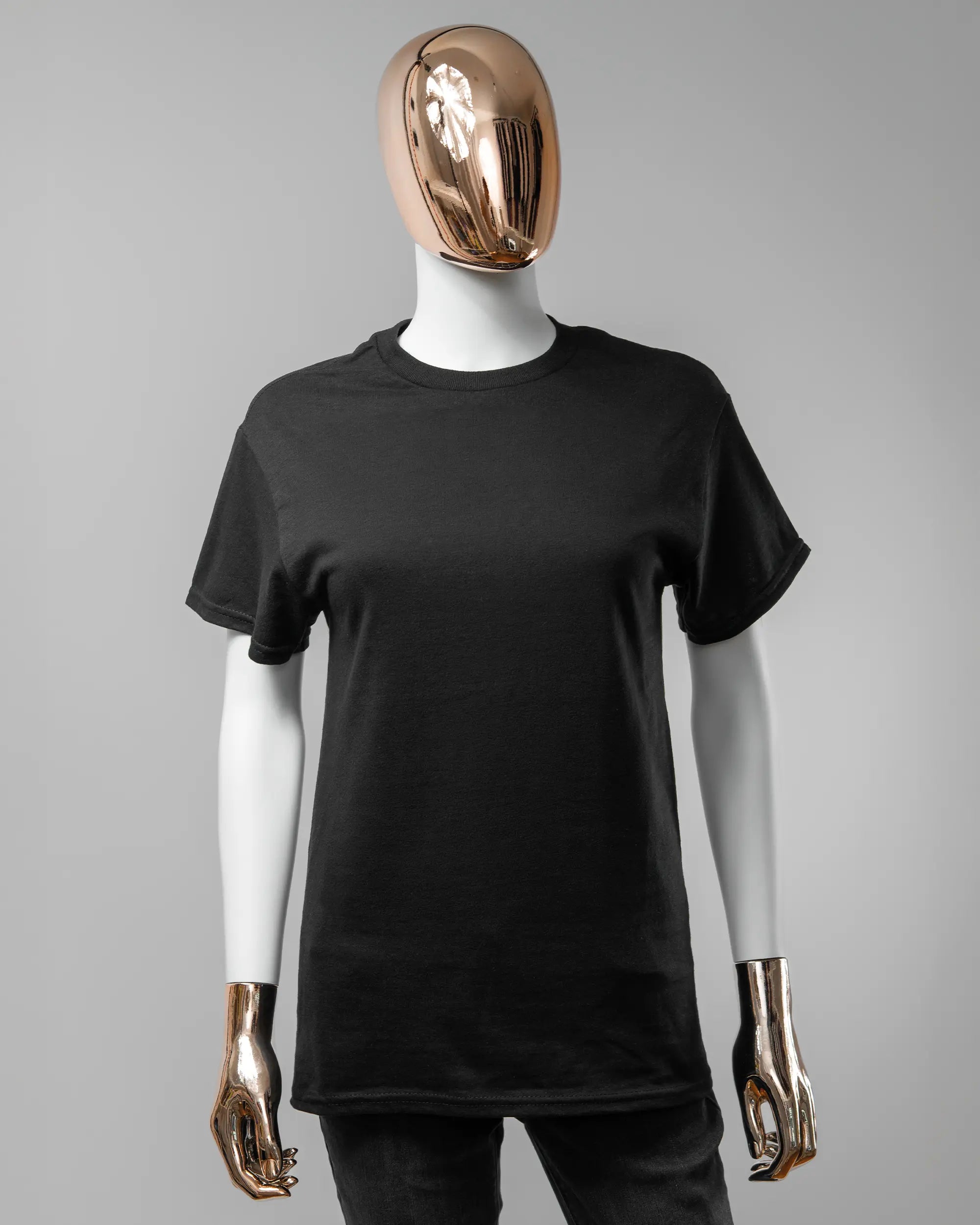 Vorderseite des Basic Unisex T-Shirt Regular von Maondo ohne Motiv in der Farbe Black und in der Größe S getragen von einer femininen Puppe