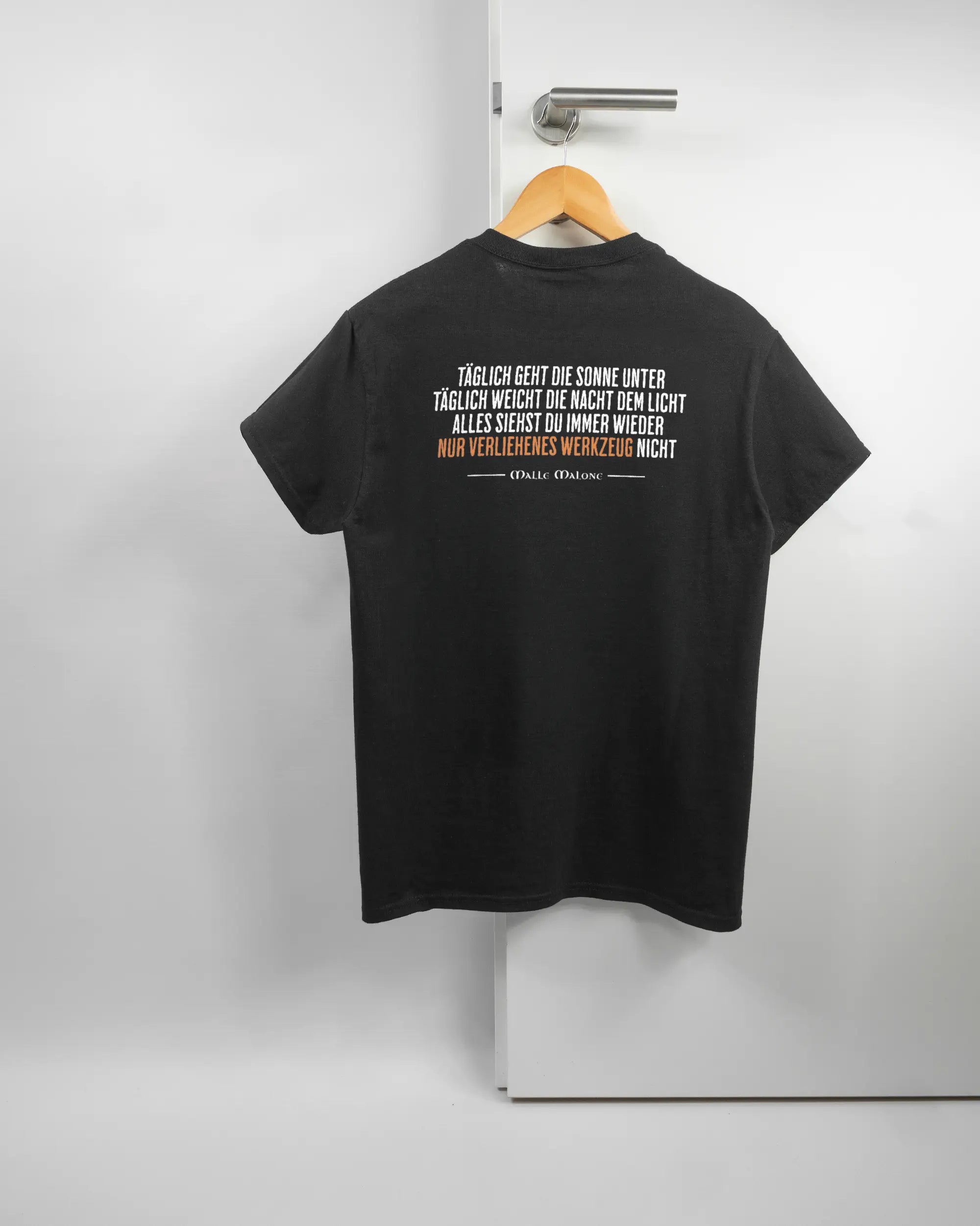 Rückseite des Basic Unisex T-Shirt Regular von Maondo mit dem Design Wegzeug in der Farbe Black und in der Größe S auf einem Bügel an der Türklinke aufgehängt
