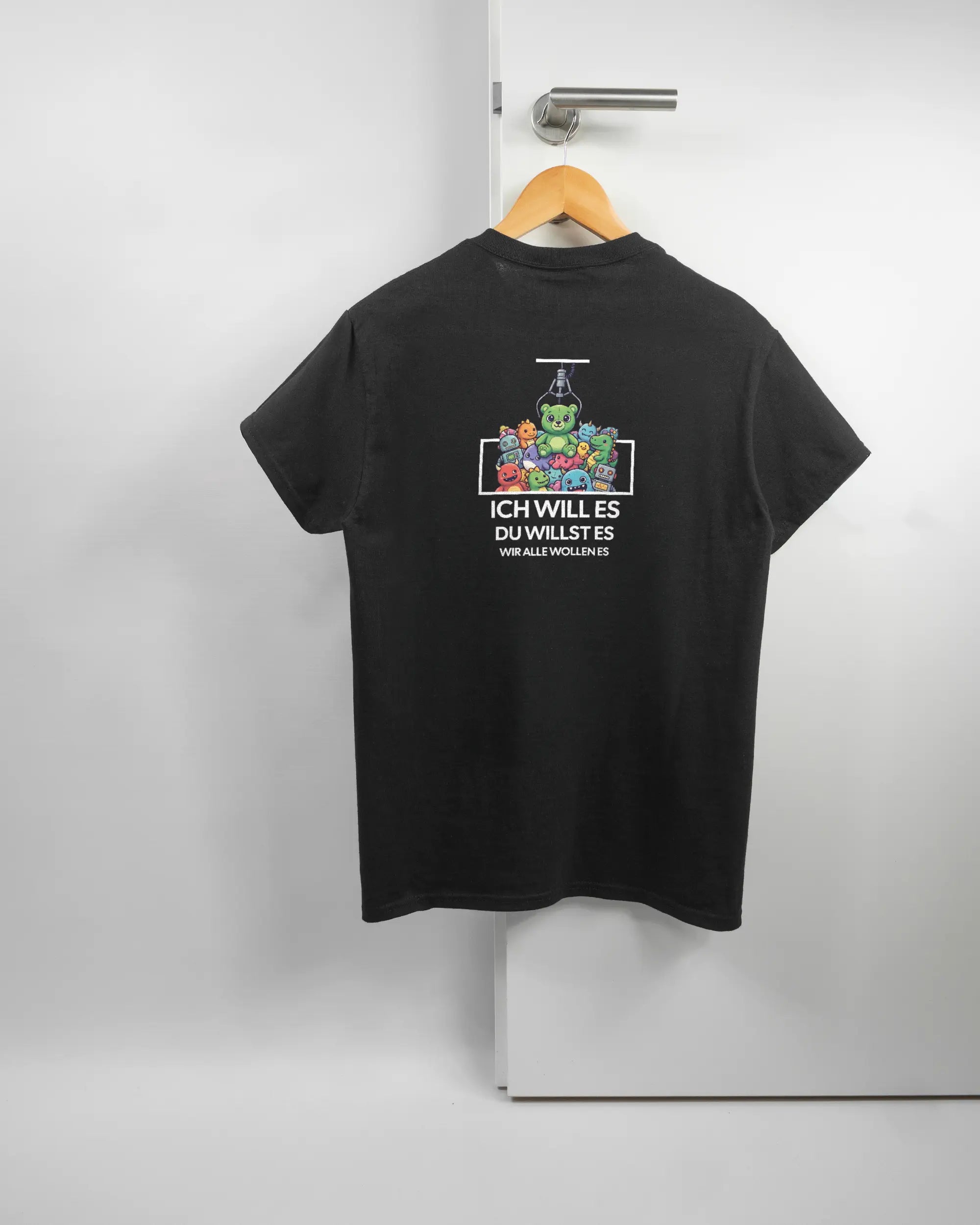 Rückseite des Basic Unisex T-Shirt Regular von Maondo mit dem Design Will Stofftier in der Farbe Black und in der Größe S auf einem Bügel an der Türklinke aufgehängt
