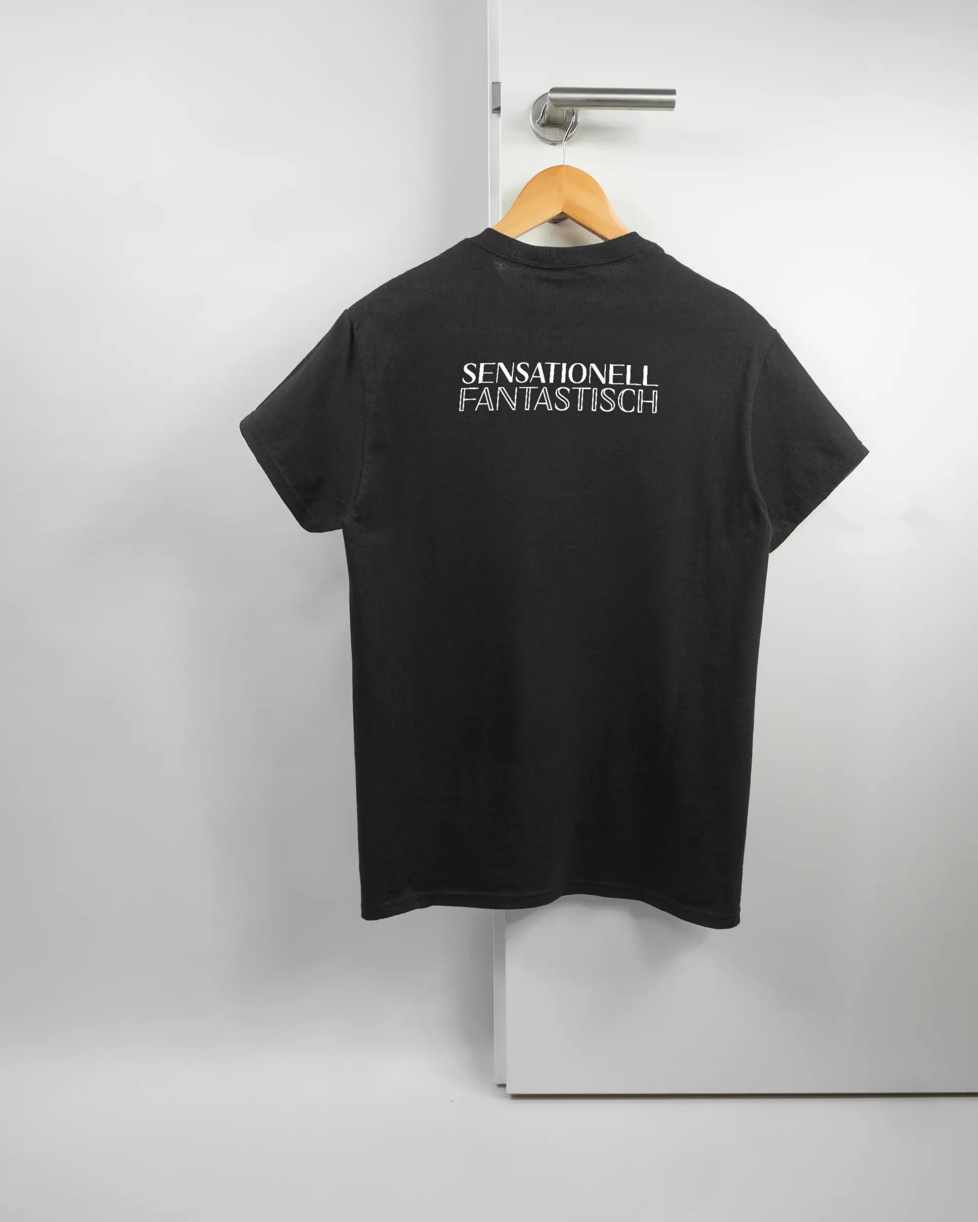 Rückseite des Basic Unisex T-Shirt Regular von Maondo mit dem Design Sensationell in der Farbe Black und in der Größe S auf einem Bügel an der Türklinke aufgehängt
