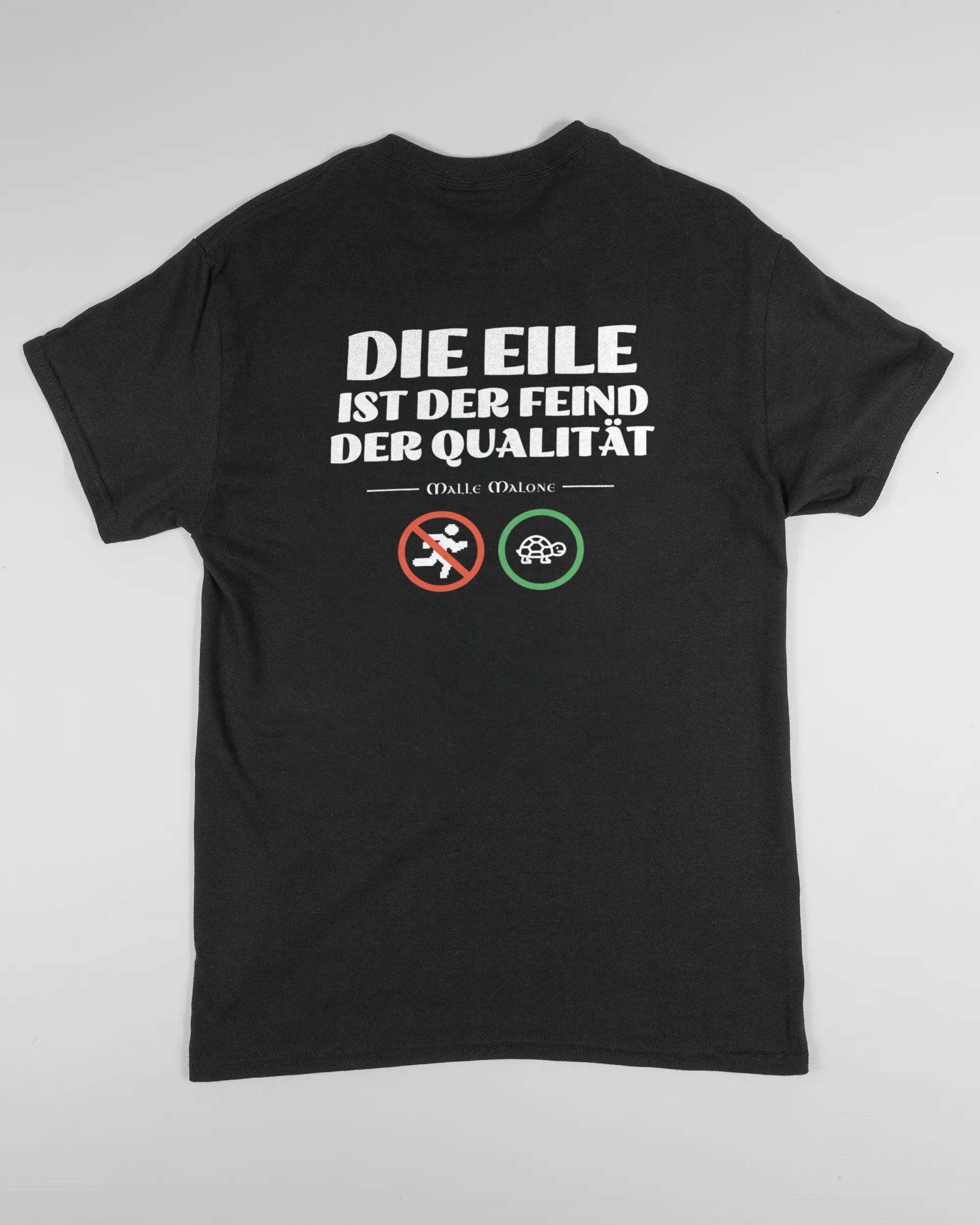 Rückseite des Basic Unisex T-Shirt Regular von Maondo mit dem Design Keine Eile in der Farbe Black und in der Größe S flach auf den Boden gelegt