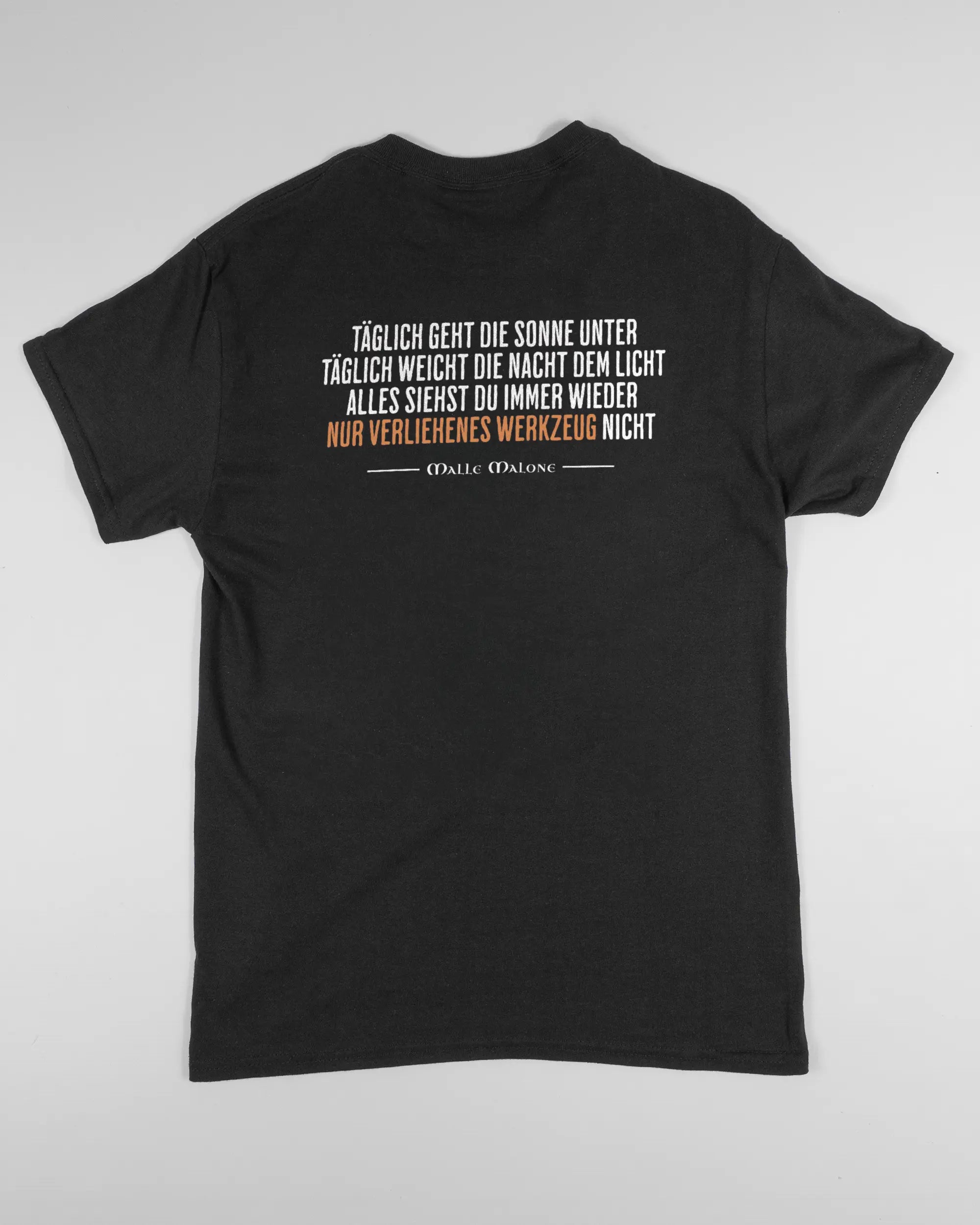 Rückseite des Basic Unisex T-Shirt Regular von Maondo mit dem Design Wegzeug in der Farbe Black und in der Größe S flach auf den Boden gelegt