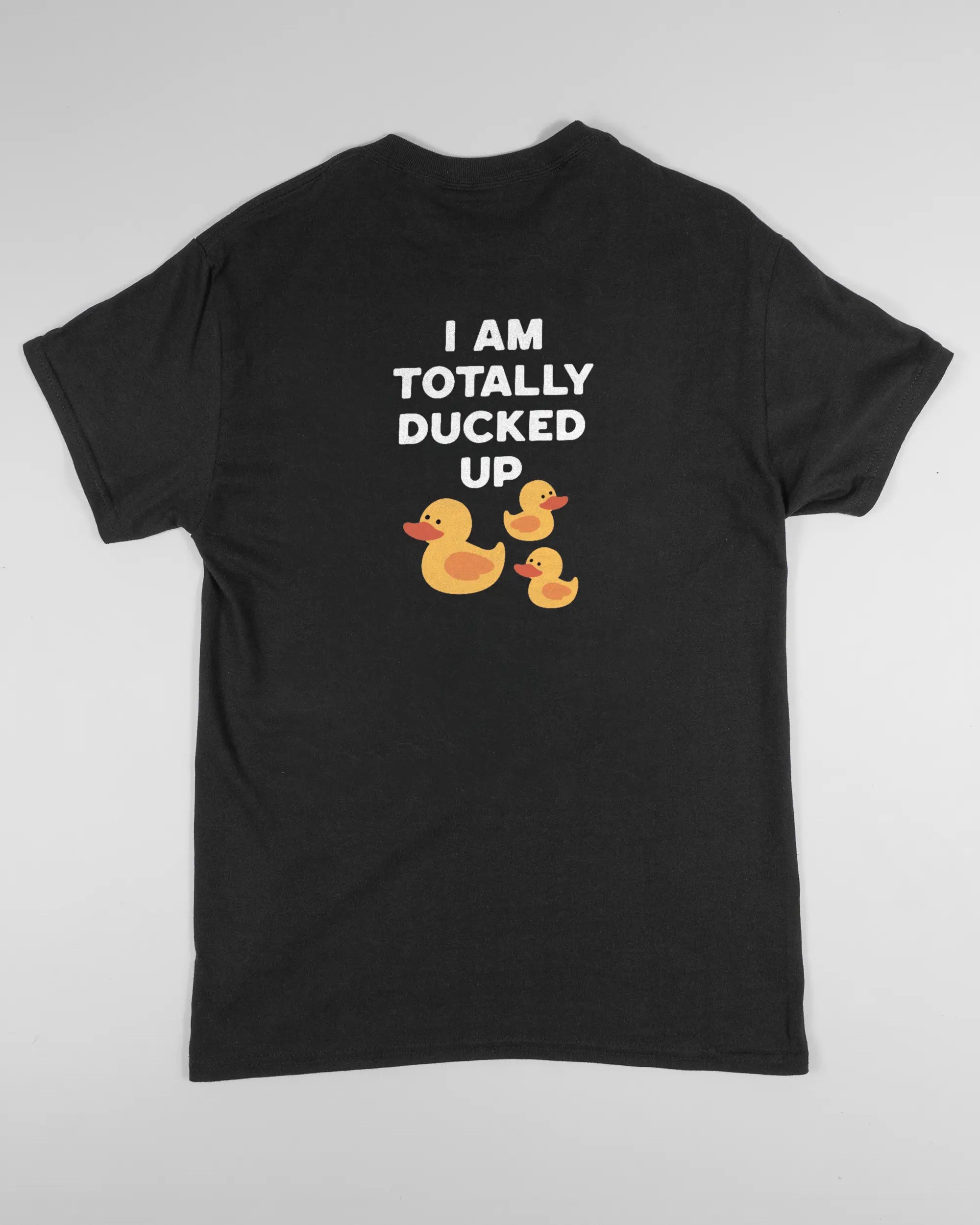 Rückseite des Basic Unisex T-Shirt Regular von Maondo mit dem Design Ducked Up in der Farbe Black und in der Größe S flach auf den Boden gelegt