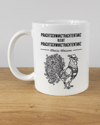 Titelbild, das die linke Seite der beidseitig bedruckten Keramiktasse von Maondo mit dem Design Trachtentanz in der Farbe White auf einem Holztisch zeigt