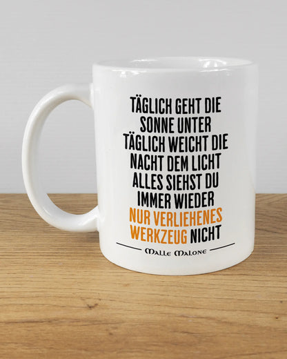 Titelbild, das die linke Seite der beidseitig bedruckten Keramiktasse von Maondo mit dem Design Wegzeug in der Farbe White auf einem Holztisch zeigt