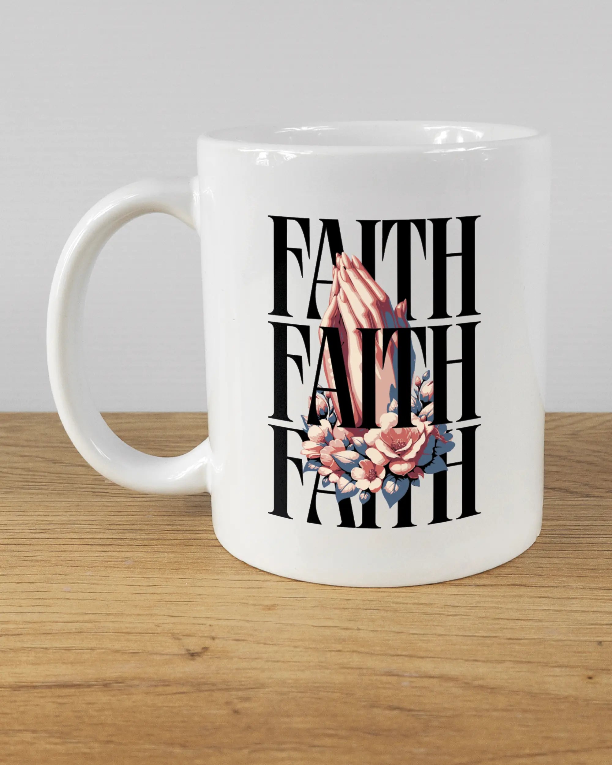 Titelbild, das die linke Seite der beidseitig bedruckten Keramiktasse von Maondo mit dem Design Faith X3 in der Farbe White auf einem Holztisch zeigt