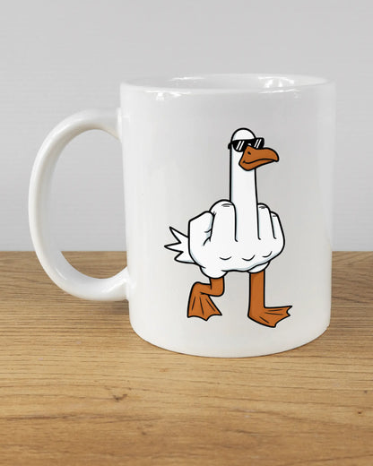 Titelbild, das die linke Seite der beidseitig bedruckten Keramiktasse von Maondo mit dem Design I give a duck in der Farbe White auf einem Holztisch zeigt